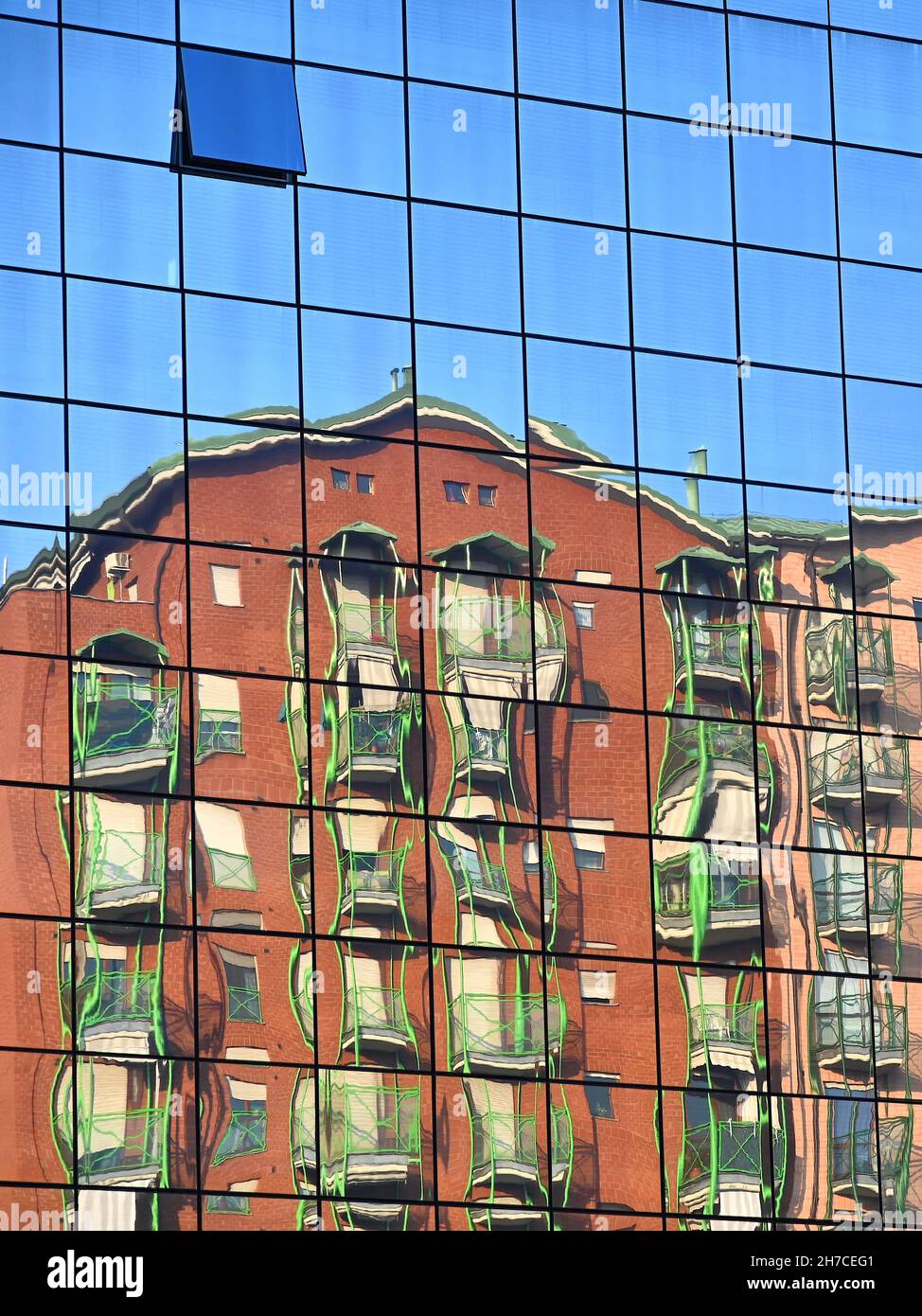 Vertikale Aufnahme einer verzerrten Spiegelung von Wohngebäuden in der Spiegelfassade Stockfoto