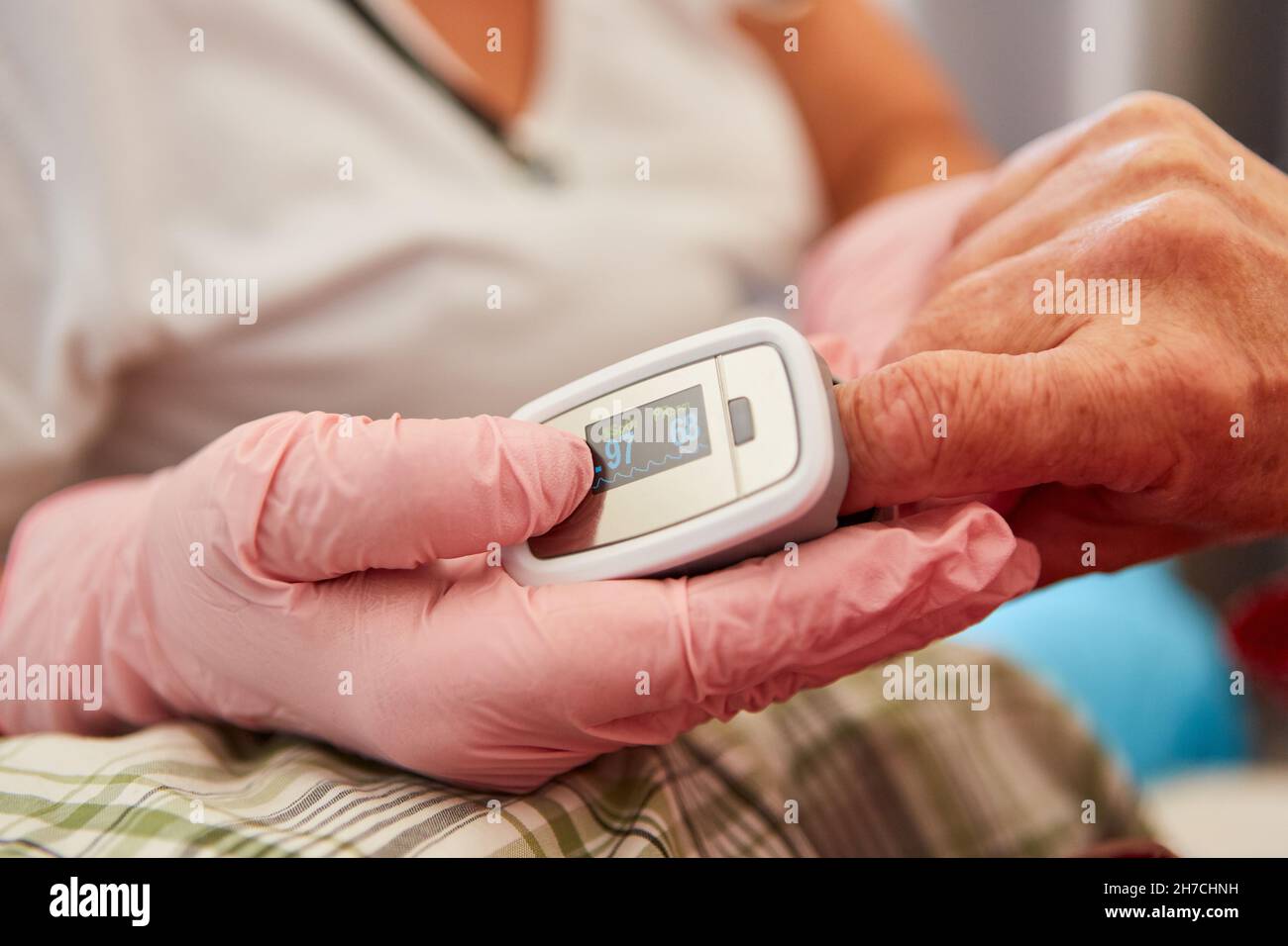 Pulsoximeter am Finger eines Patienten zur Messung von Puls und Sauerstoffsättigung Stockfoto