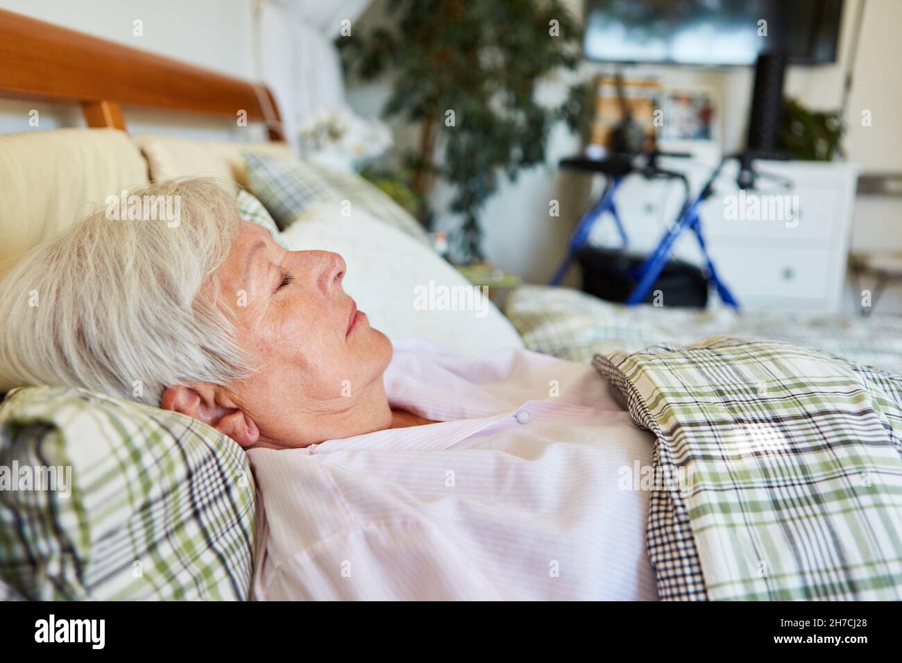 Die alte Frau schläft gut im Bett im Altersheim oder zu Hause Stockfoto