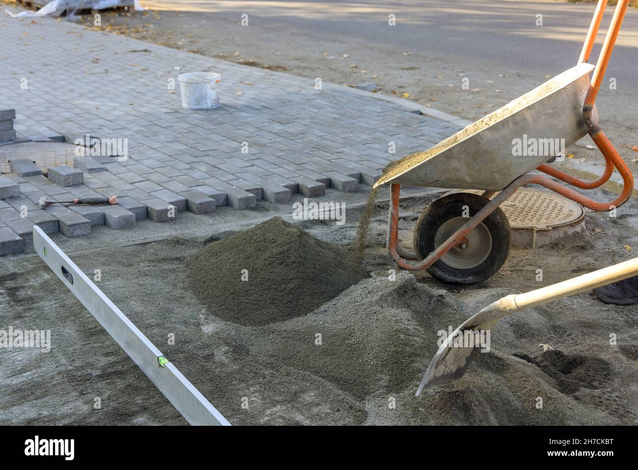 Die Straße arbeitet auf der Straße in der Stadt mit der Vorbereitung der Oberfläche, die Ziegel des sandigen Sandbundes zu stellen Stockfoto