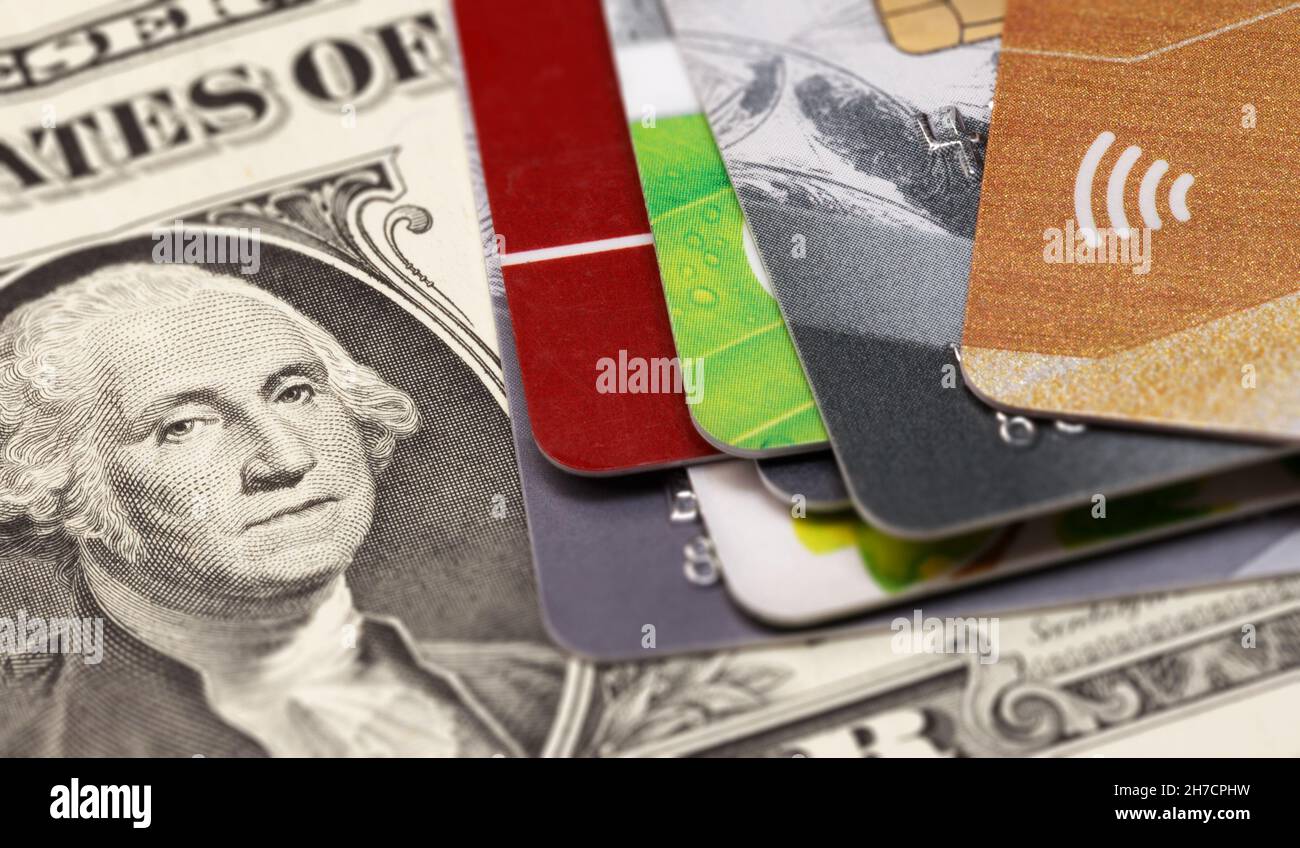 Auf einer ein-Dollar-Rechnung liegt ein Stapel Kreditkarten mit dem kontaktlosen Symbol. Stockfoto