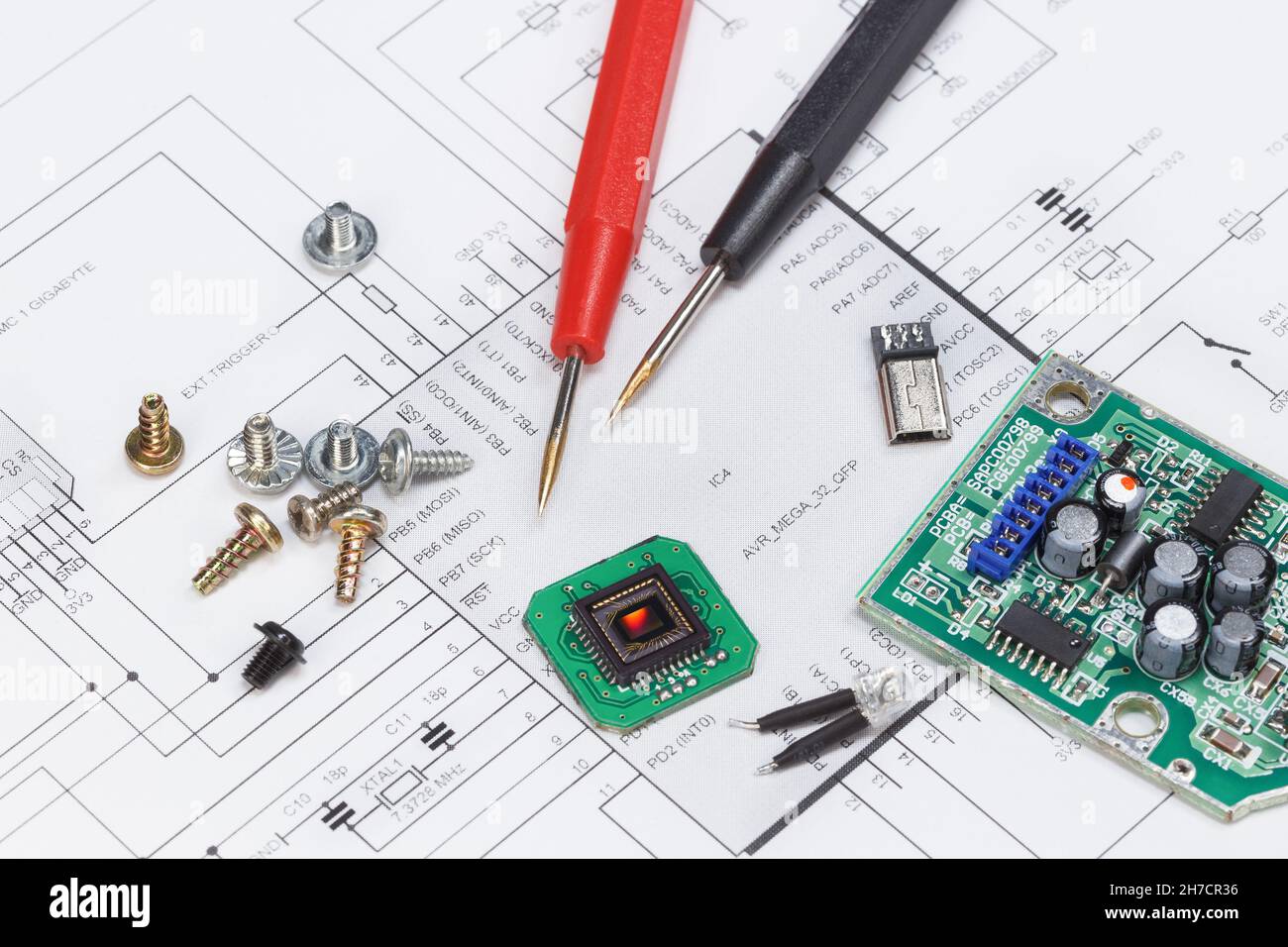 Diagramm eines elektronischen Geräts und darauf liegender elektronischer Module, Schrauben und Teile Stockfoto