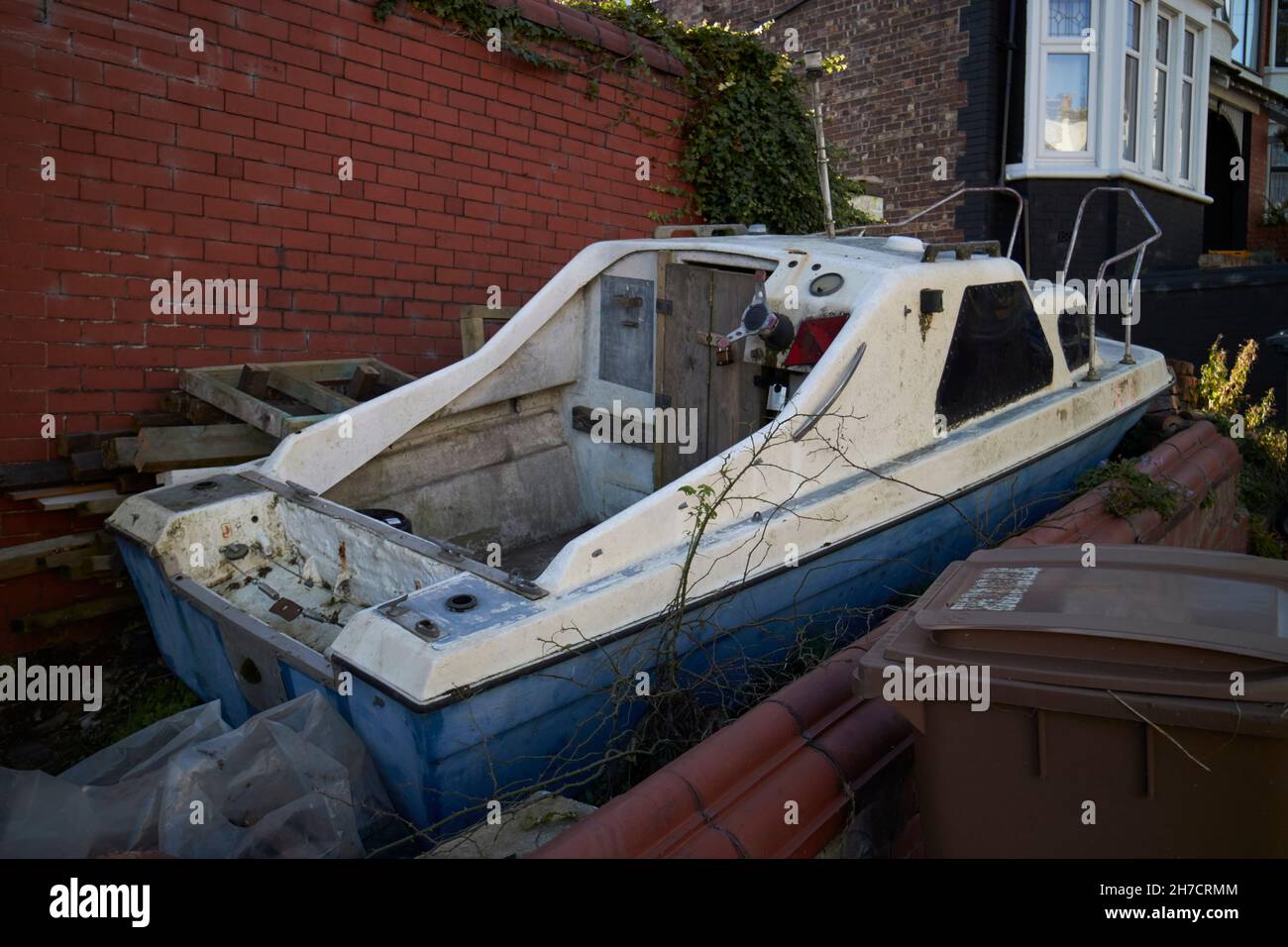 Altes kleines Fischerboot, das ungenutzt in einem Garten liegt New Brighton The Wirral merseyside uk Stockfoto
