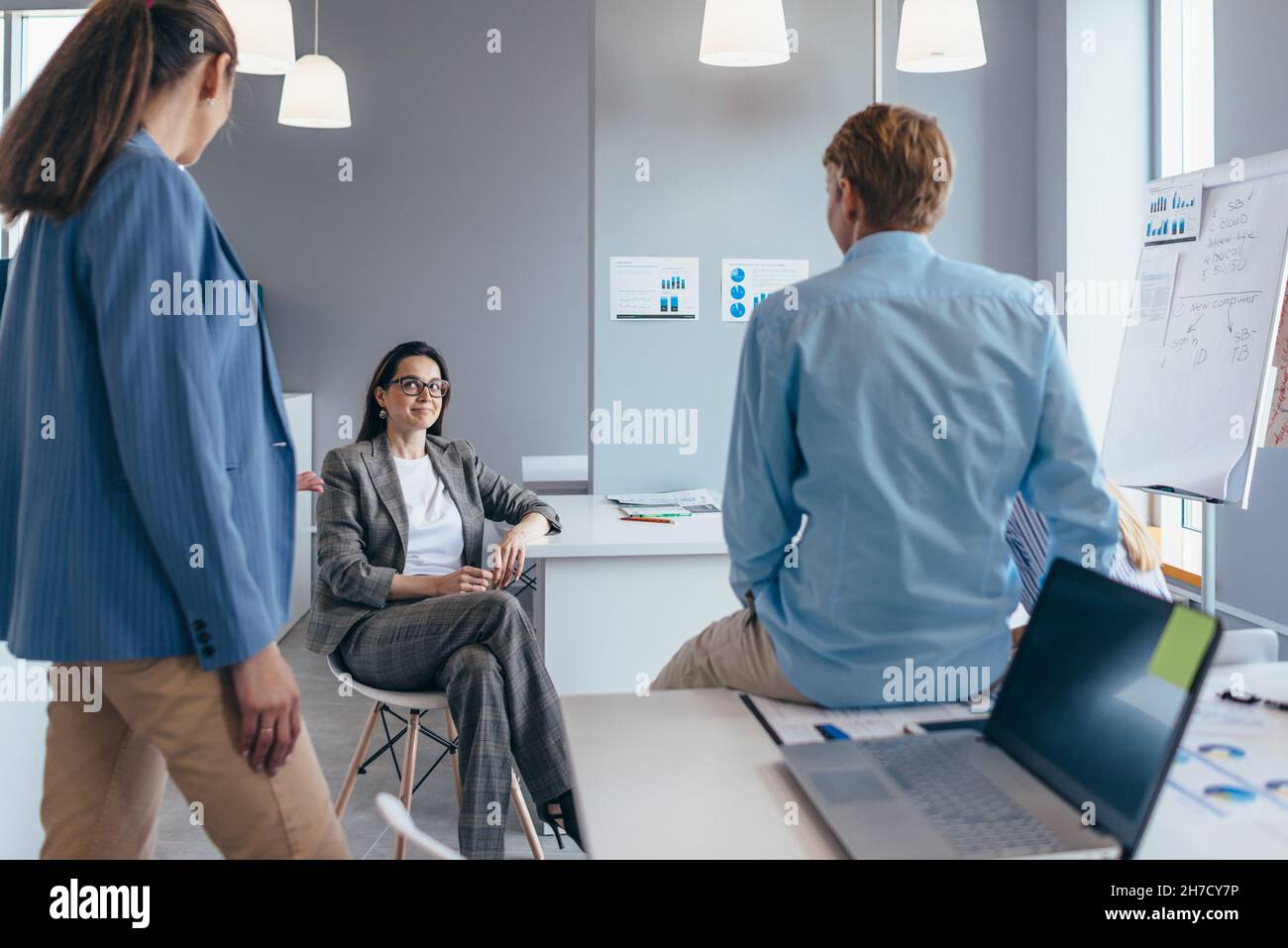 Eine Gruppe von Mitarbeitern versammelt sich informell im Büro und plaudert. Stockfoto