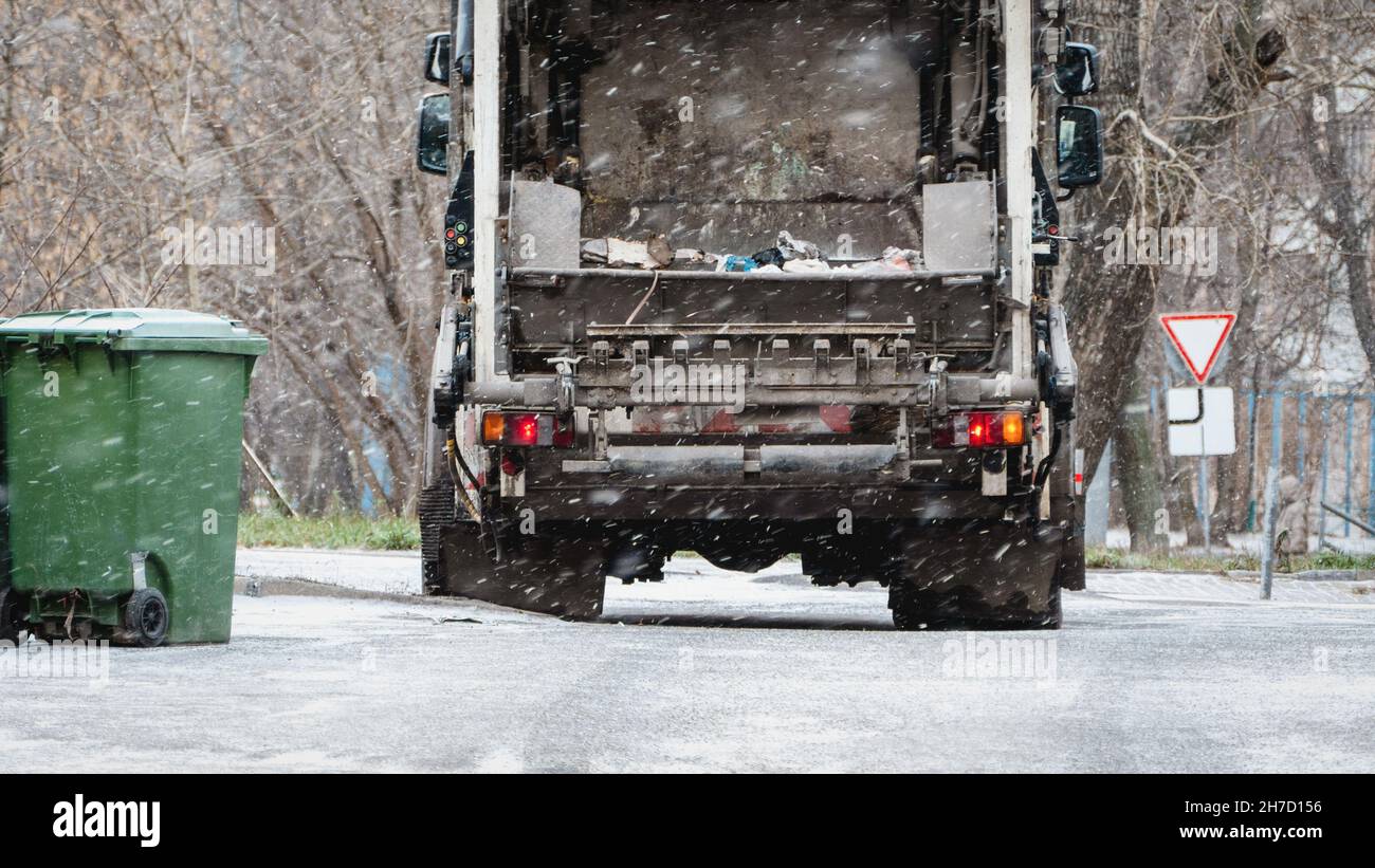 Müllwagen, Mülleimer mit Mülllift, Abfallentsorgung in Wohngebieten im Winter, Müllcontainer, Schnee Stockfoto