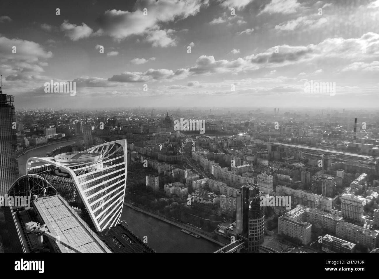 Stadtbild mit moderner Architektur und Fluss unter bewölktem Himmel Stockfoto