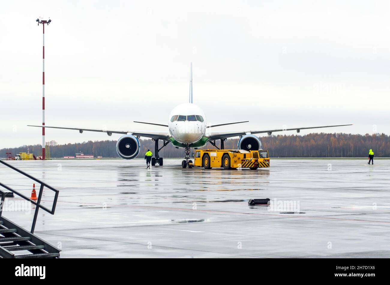 Abschleppwagen, der das Flugzeug zum Parkplatz am Flughafen zurückschiebt Stockfoto