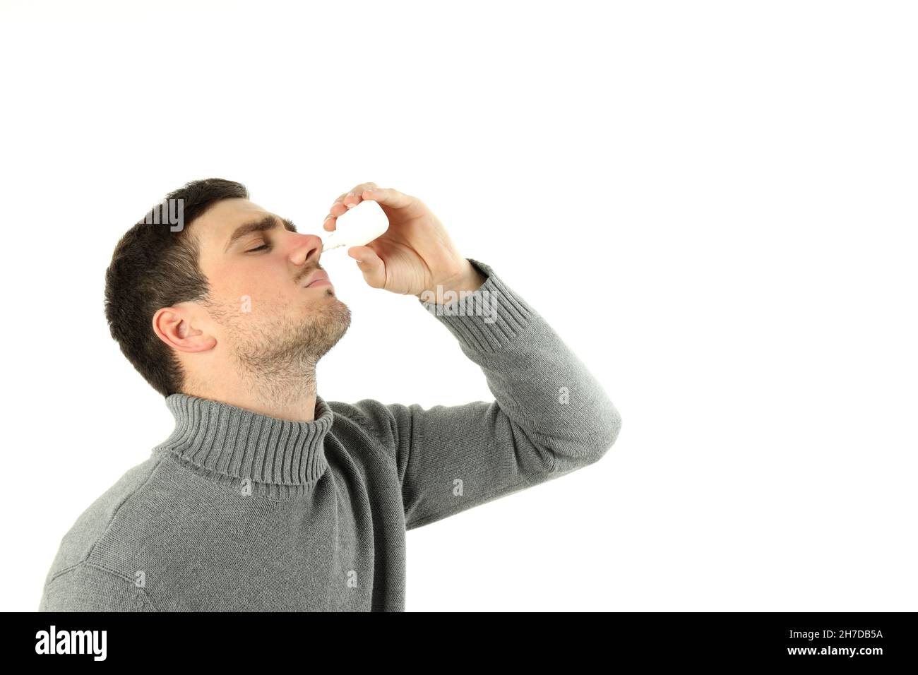 Junger Mann mit Nasenspray isoliert auf weißem Hintergrund Stockfoto