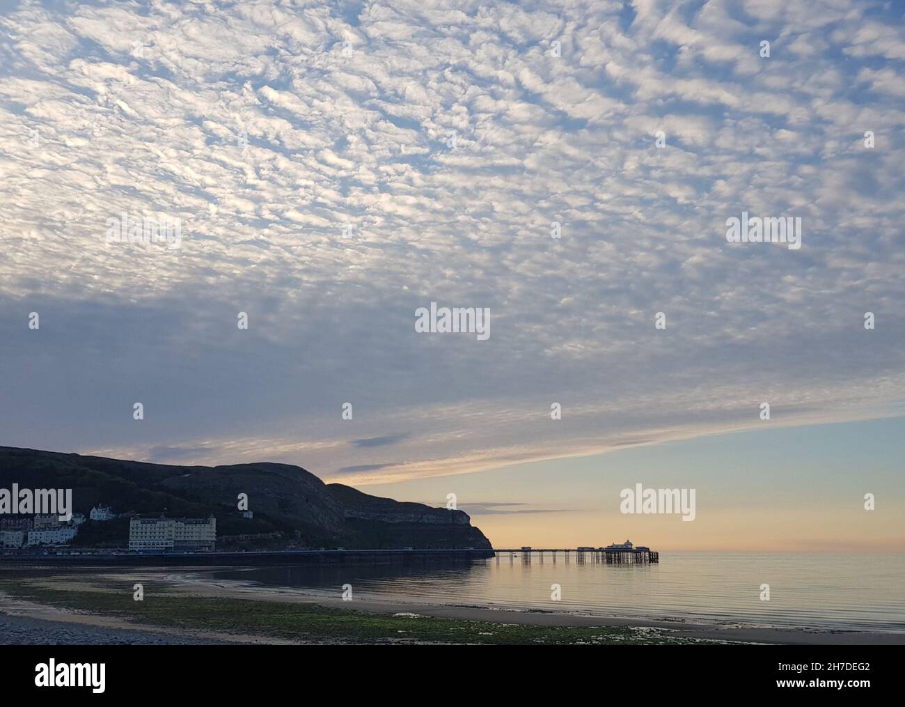 Blick auf den Pier von Llandudno und die große Orme unter einem sehr bewölkten Himmel Stockfoto