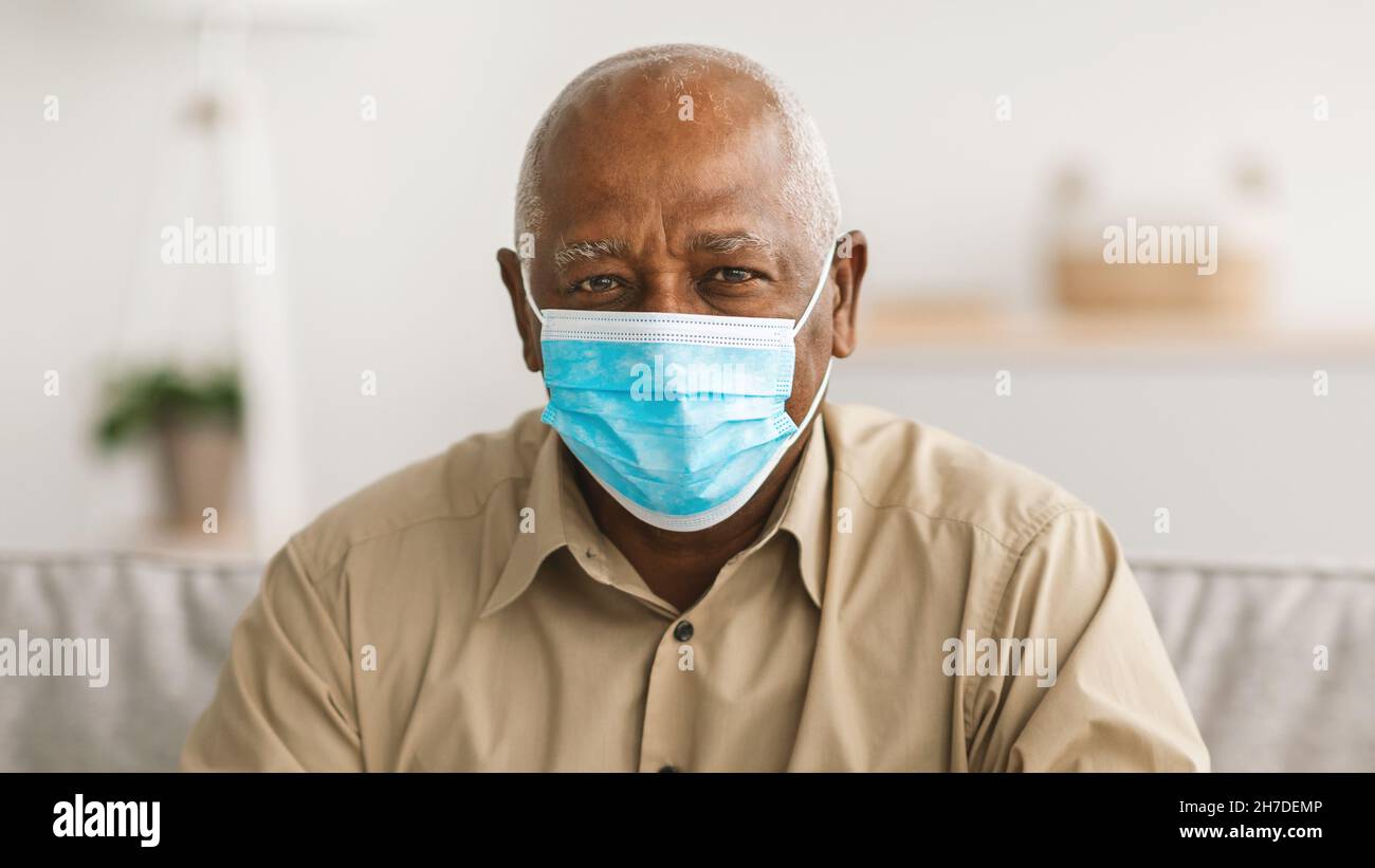 Älterer Afroamerikanischer Mann Mit Gesichtsmaske Zu Hause, Panorama Stockfoto