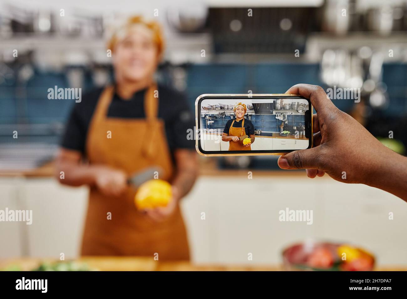 Porträt einer lächelnden Köchin auf dem Smartphone-Bildschirm, die Videos aufzeichnet oder in der Küche Livestream macht, Platz zum Kopieren Stockfoto