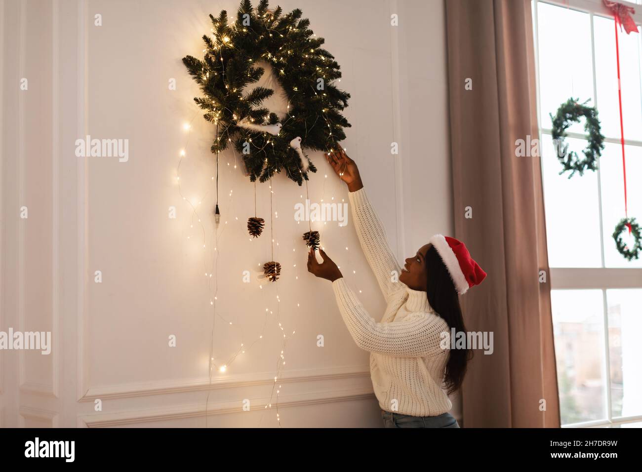 Porträt der glücklichen schwarzen Frau Dekoration Wohnung für Weihnachten Stockfoto