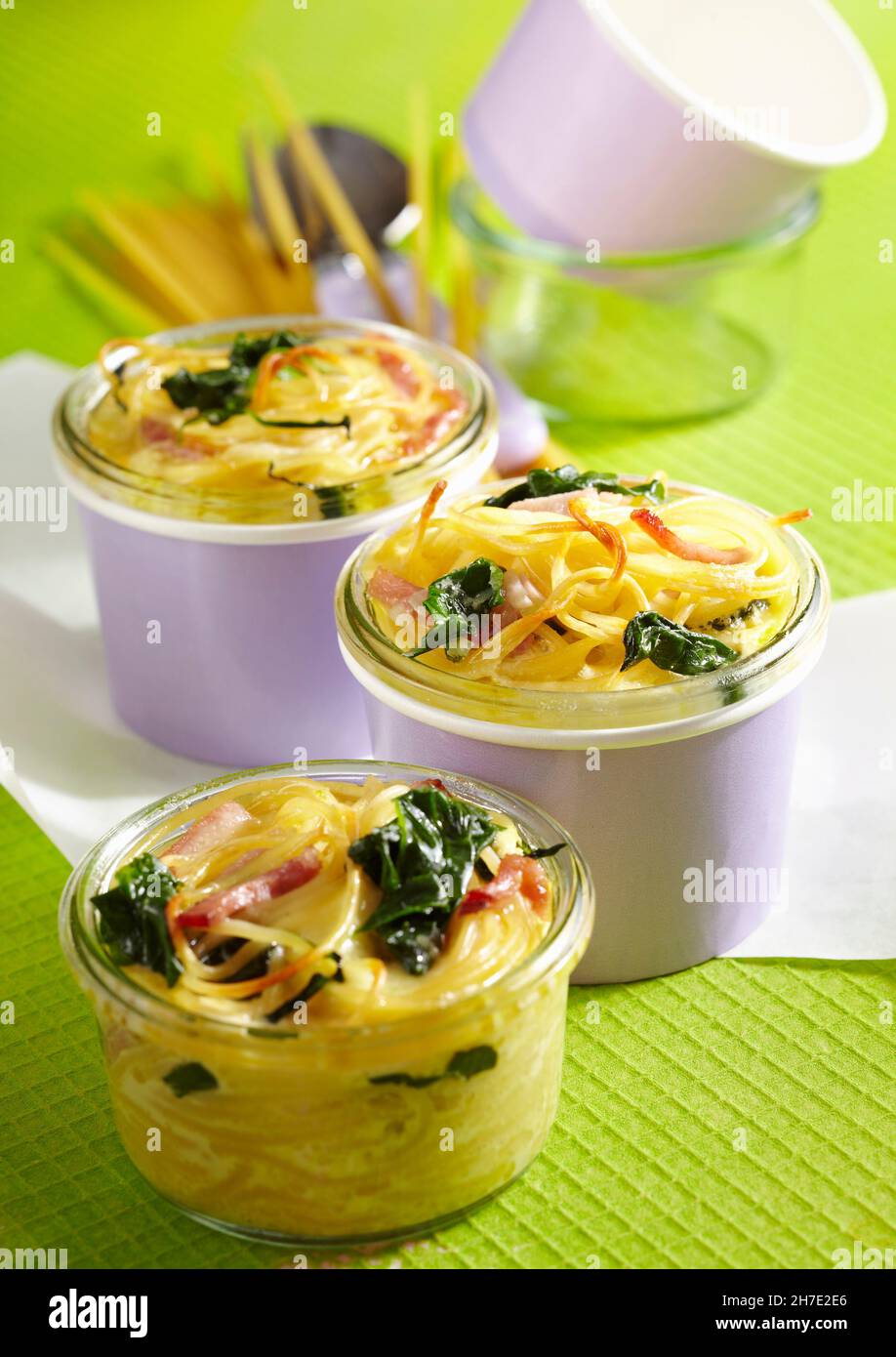 Bunt gebackene Pasta mit Spinat, gekochtem Schinken und Parmesan Stockfoto