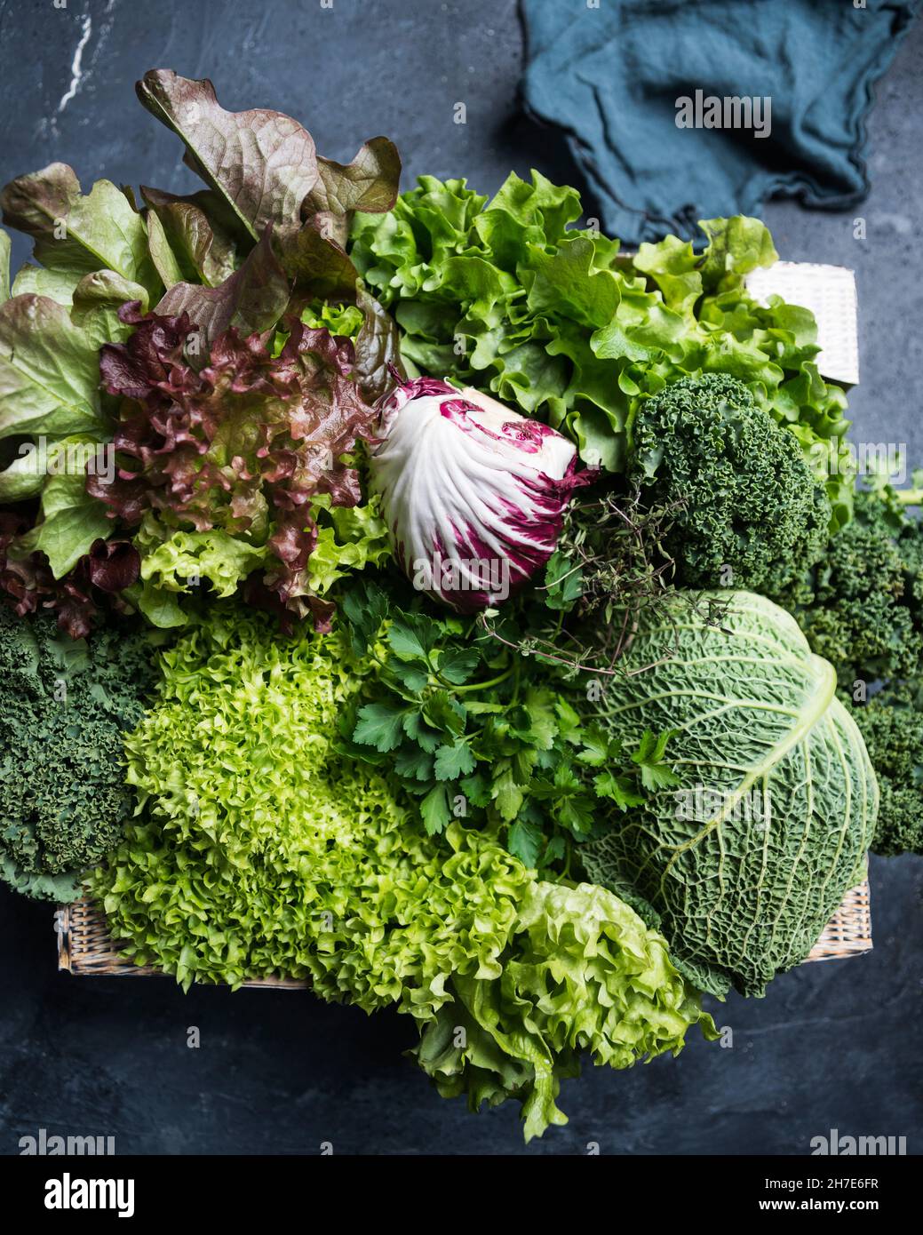 Eine Kiste mit wirsing, Petersilie, Thymian, Lollo, Grünkohl, Salat mit Eichenblättern und Radicchio Stockfoto