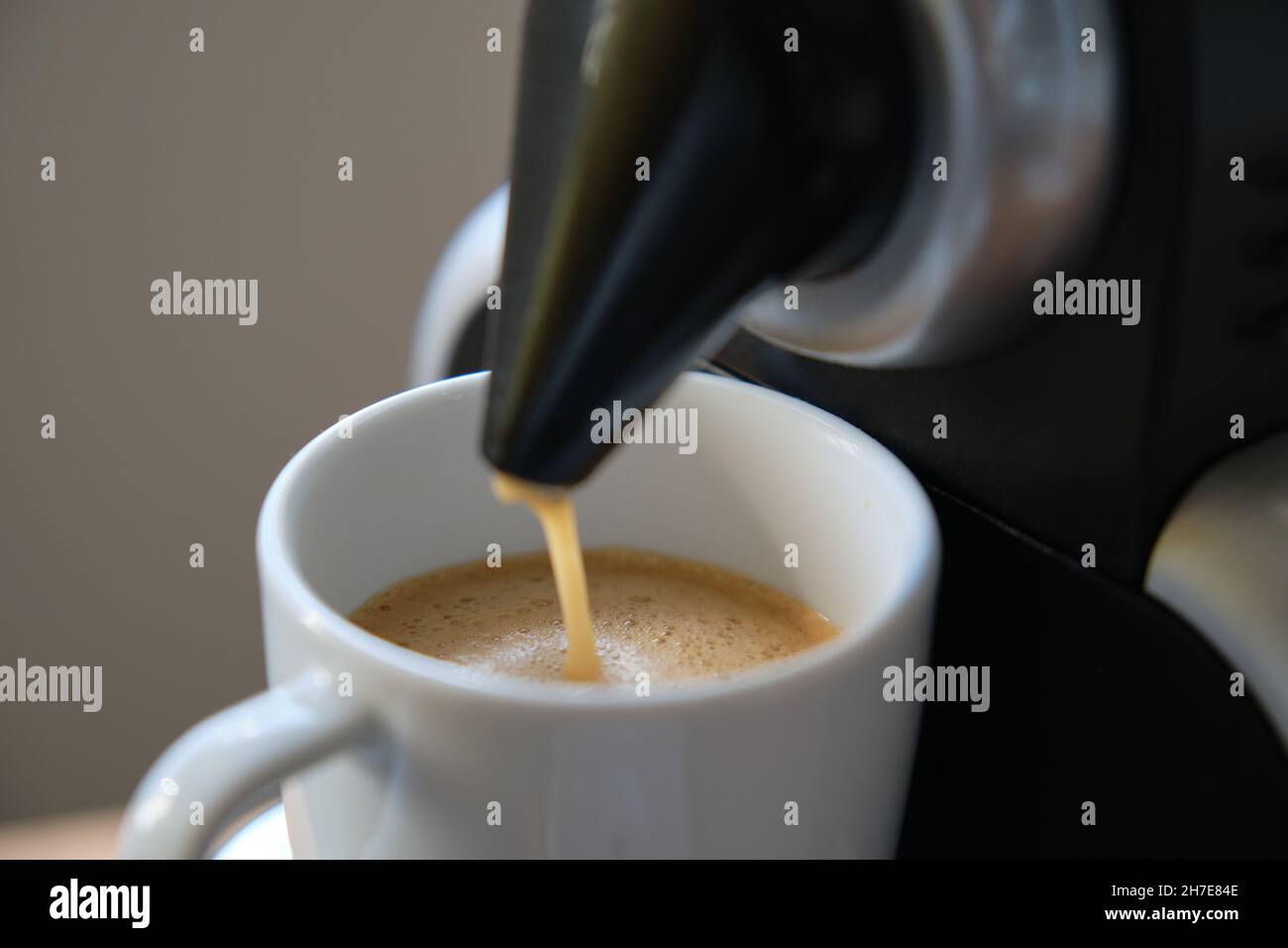 Nahaufnahme einer Kaffeemaschine, die einen Espresso in eine Tasse gießt. Stockfoto
