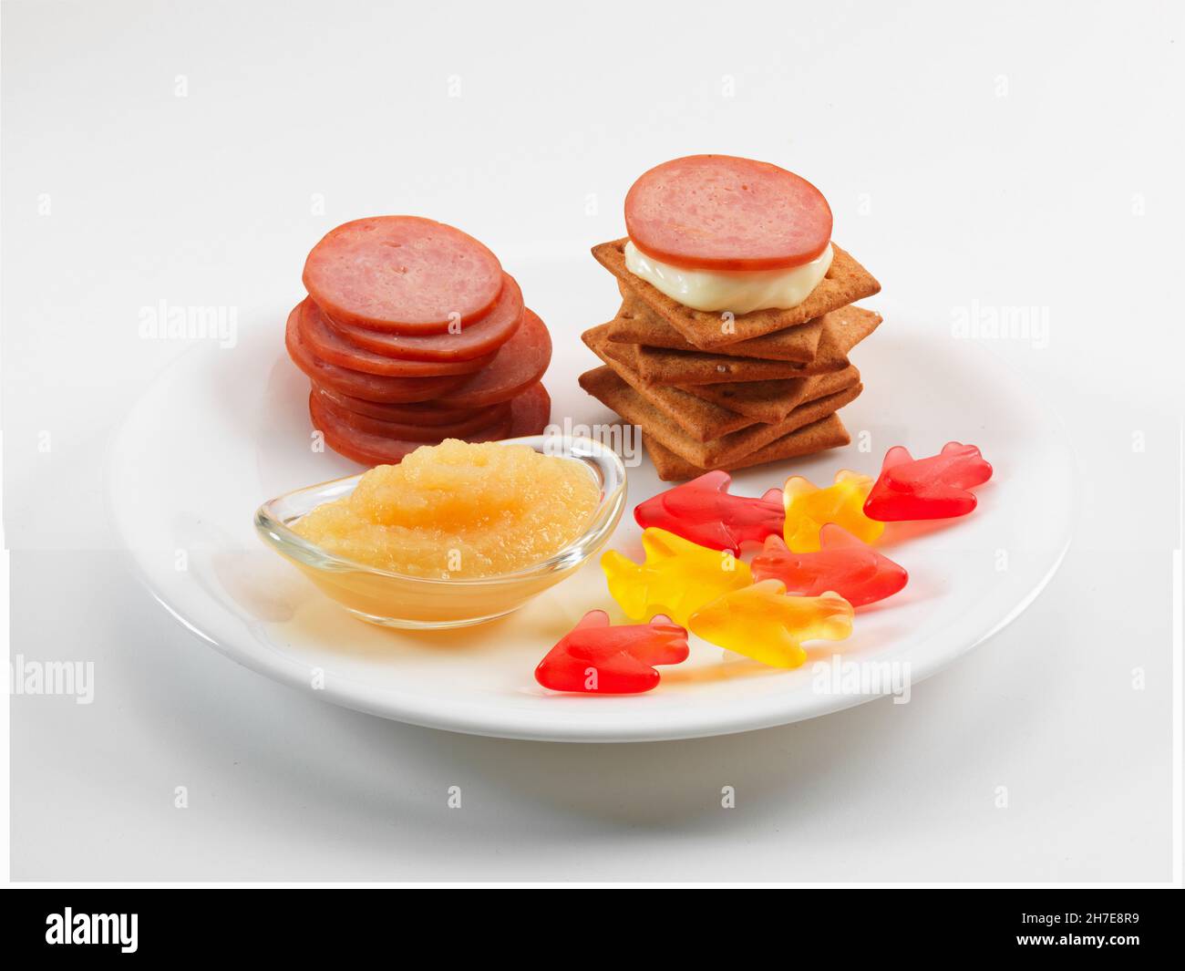 Cracker mit Wurstscheiben und Käse serviert mit Apfelmus und Weingummi Stockfoto