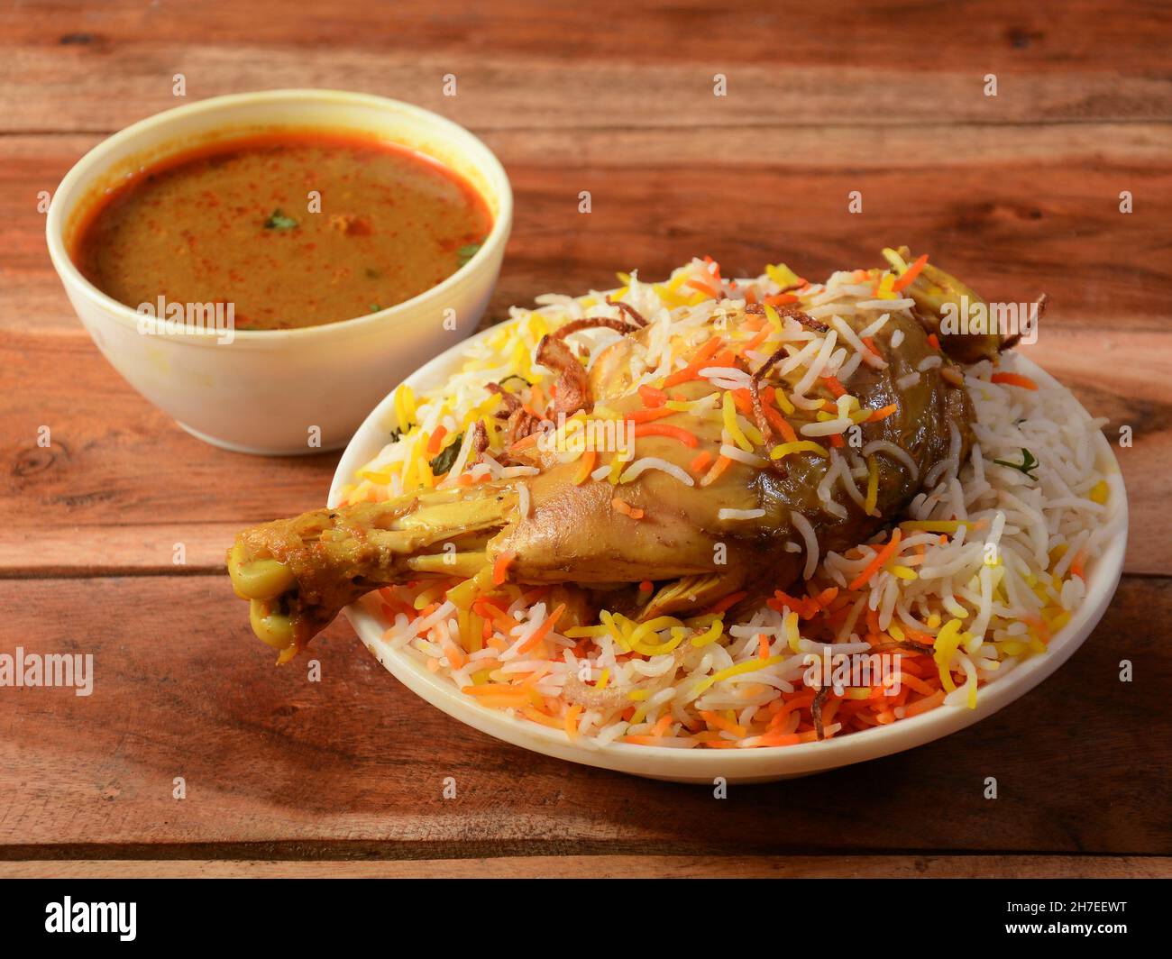 Traditionelles Hyderabadi Chicken dum Biryani aus Basmati-Reis, zubereitet mit Masala-Gewürzen, serviert mit Salan, selektiver Fokus Stockfoto