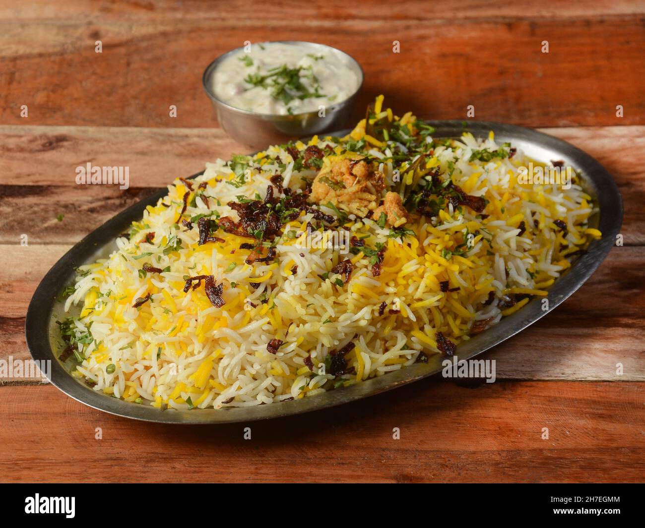 Traditionelles hyderabadi Gemüse / Gemüse dum biryani mit gemischtem Gemüse serviert mit gemischter Raita, selektiver Konzentration Stockfoto