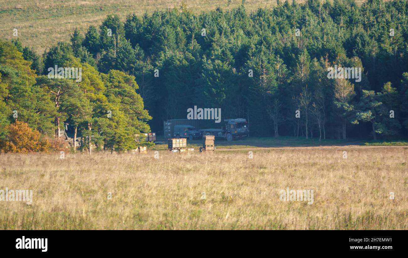 Metallschiffcontainer versteckt zwischen Wäldern und geschützt von britischen Infanteriesoldaten bei einer militärischen Übung, Wiltshire UK Stockfoto