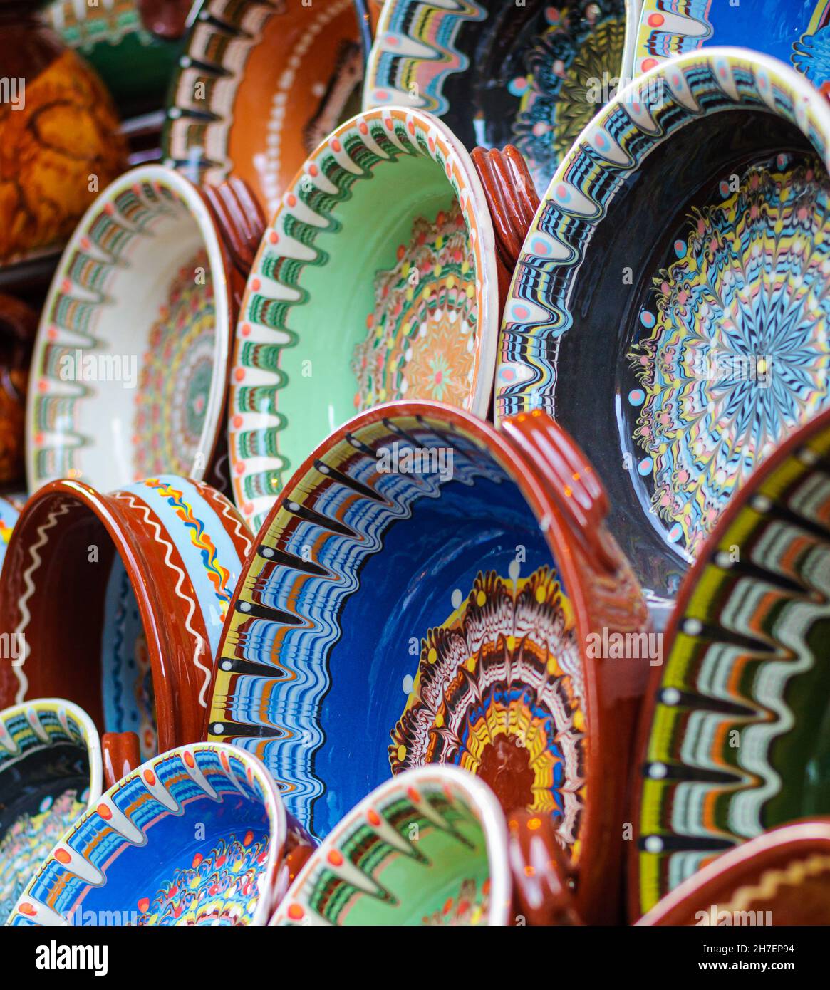 Bemalte bulgarische Keramikgefäße mit traditionellen Motiven, Teller, Schalen, Becher. Handgefertigt aus braunem Ton. Gebackene Glasur bei hoher Temperatur Stockfoto