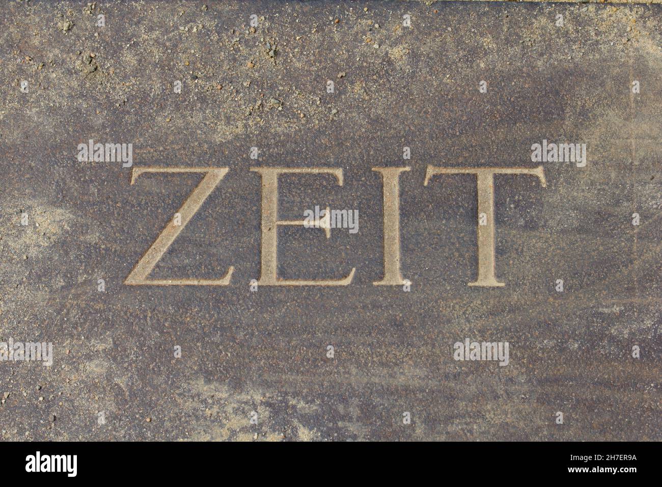 Sand der Zeit. Eingraviertes Wort ZEIT Teil bedeckt mit Sand Stockfoto