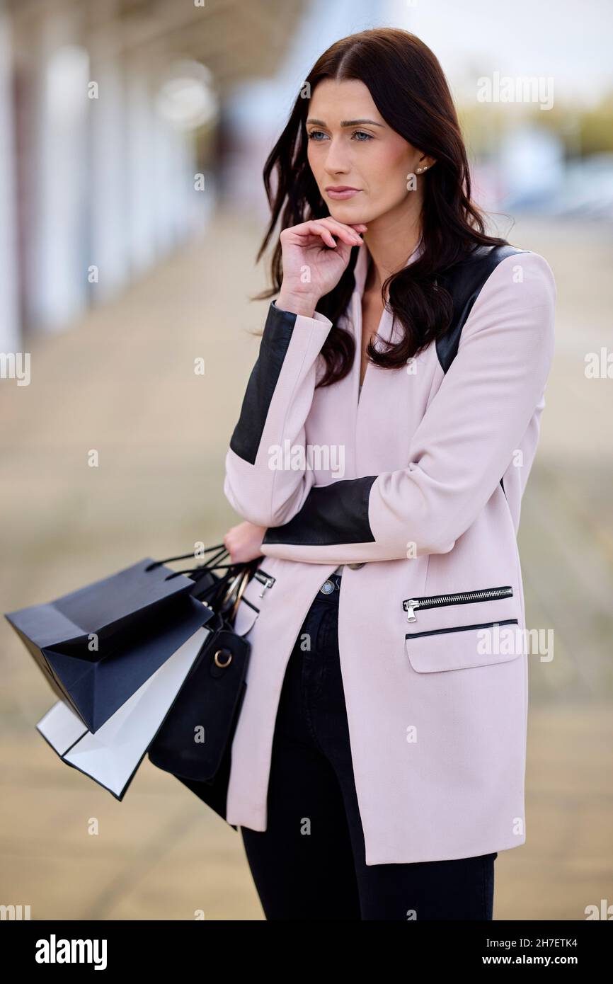 Müde Frau mit Einkaufstüten Stockfoto