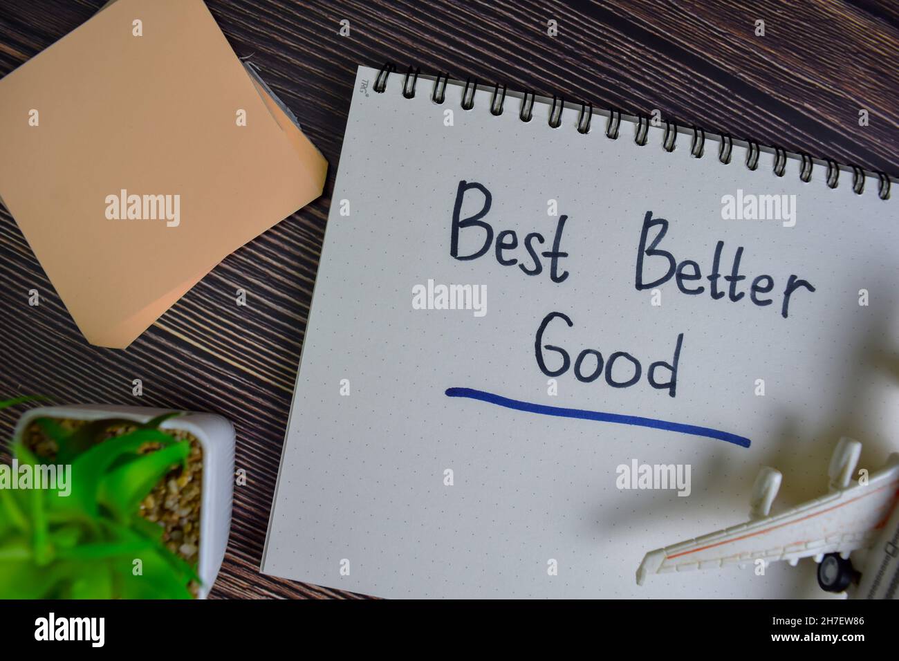 Am besten besser gut Schreiben Sie auf ein Buch isoliert auf Holztisch. Stockfoto