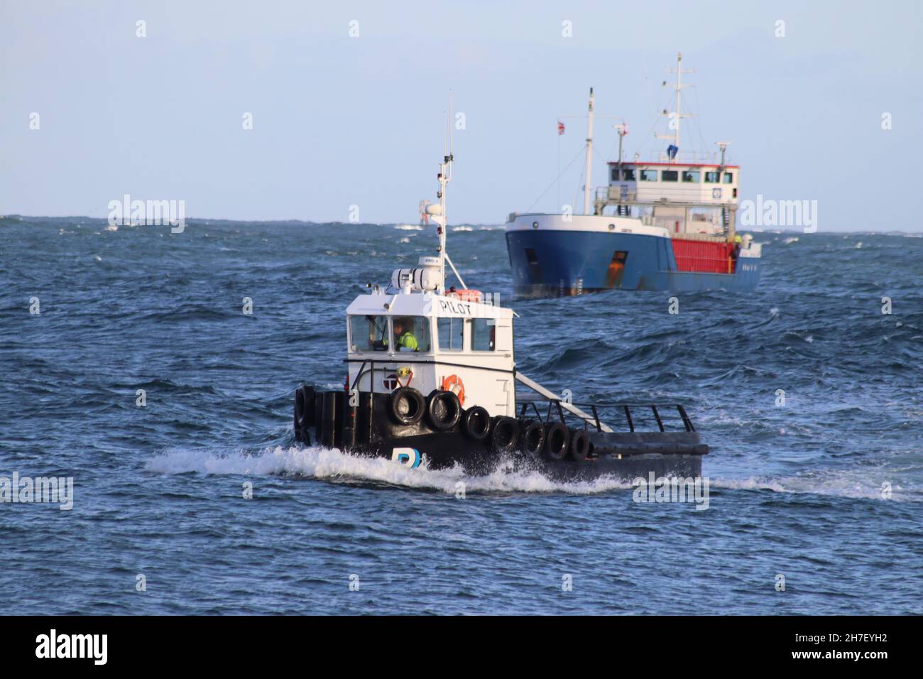 Lotsenboot, das das Schiff in den Hafen führt Stockfoto