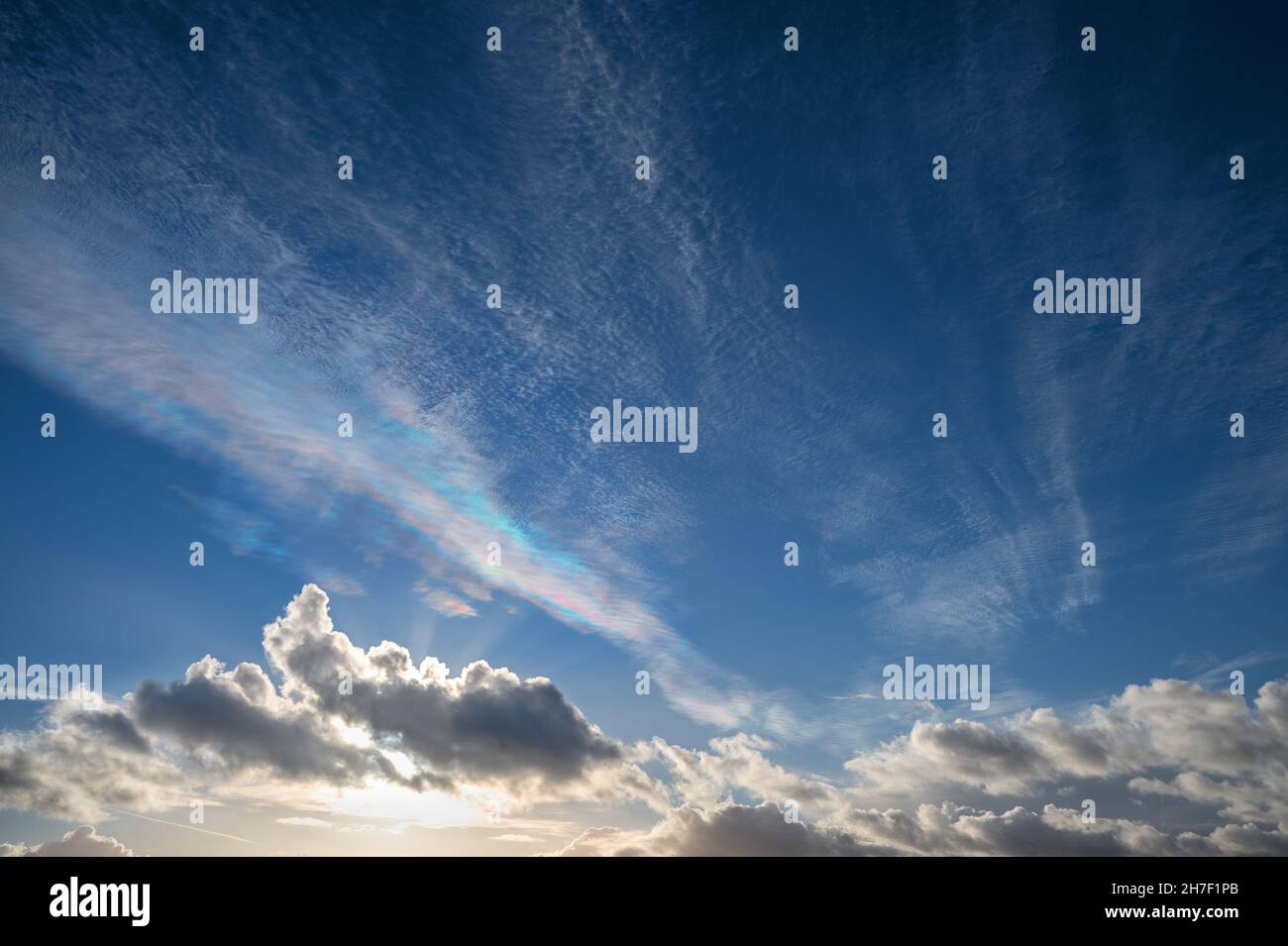 Cirrocumulus undulatus Wolken mit irisierenden Spektralfarben durch Reflexion oder Brechung, ein optisches Phänomen gegen einen tiefen Himmel, Kopierraum, selec Stockfoto