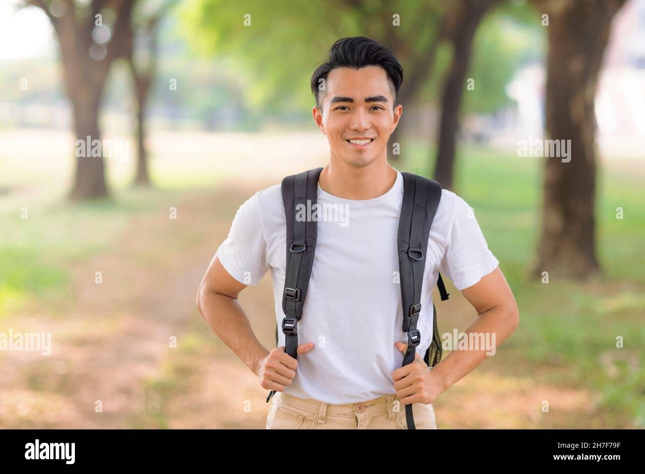 Lächelnder asiatischer junger Mann, der die Kamera anschaut Stockfoto