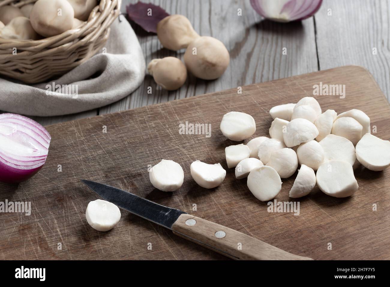 Kochen von essbaren Puffball-Pilzen. Zerschneiden von geschälten Pilzen auf einem Schneidebrett. Stockfoto