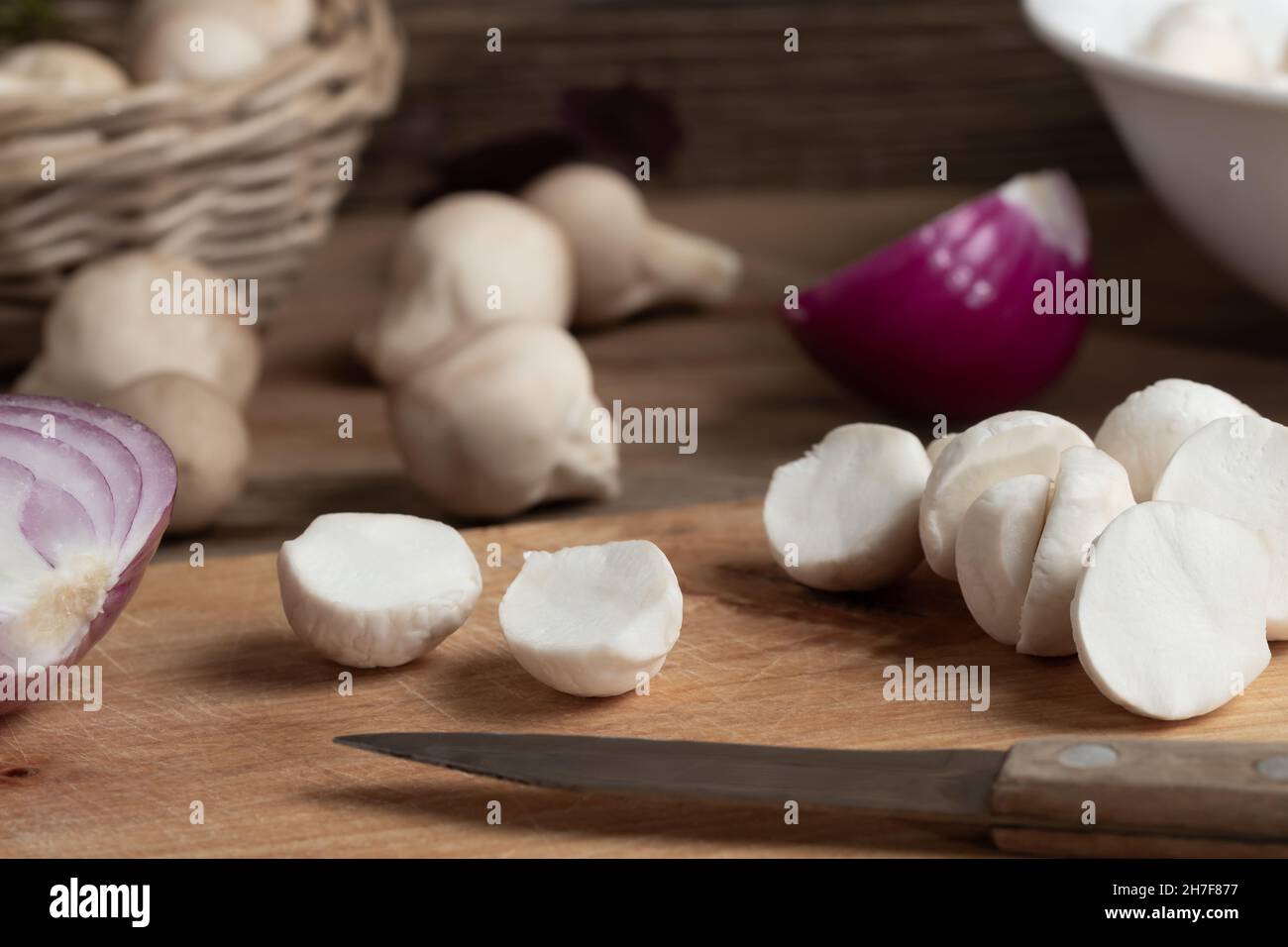 Kochen von essbaren Puffball-Pilzen. Zerschneiden von geschälten Pilzen auf einem Schneidebrett, Nahaufnahme. Stockfoto