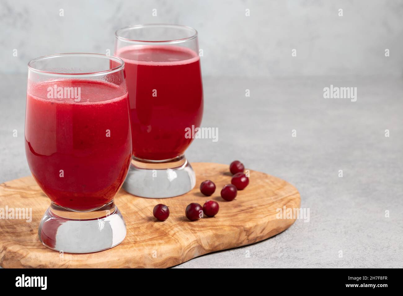 Zwei Gläser mit hausgemachtem frisch Preiselbeersaft auf einem grauen Betontisch. Stockfoto