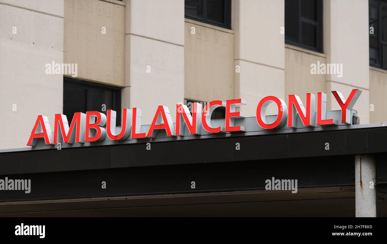 Ein Krankenwagen Schild nur an einem Eingang zu einem Krankenhaus. Die Beschilderung ist in Großbuchstaben in Rot gehalten. Stockfoto