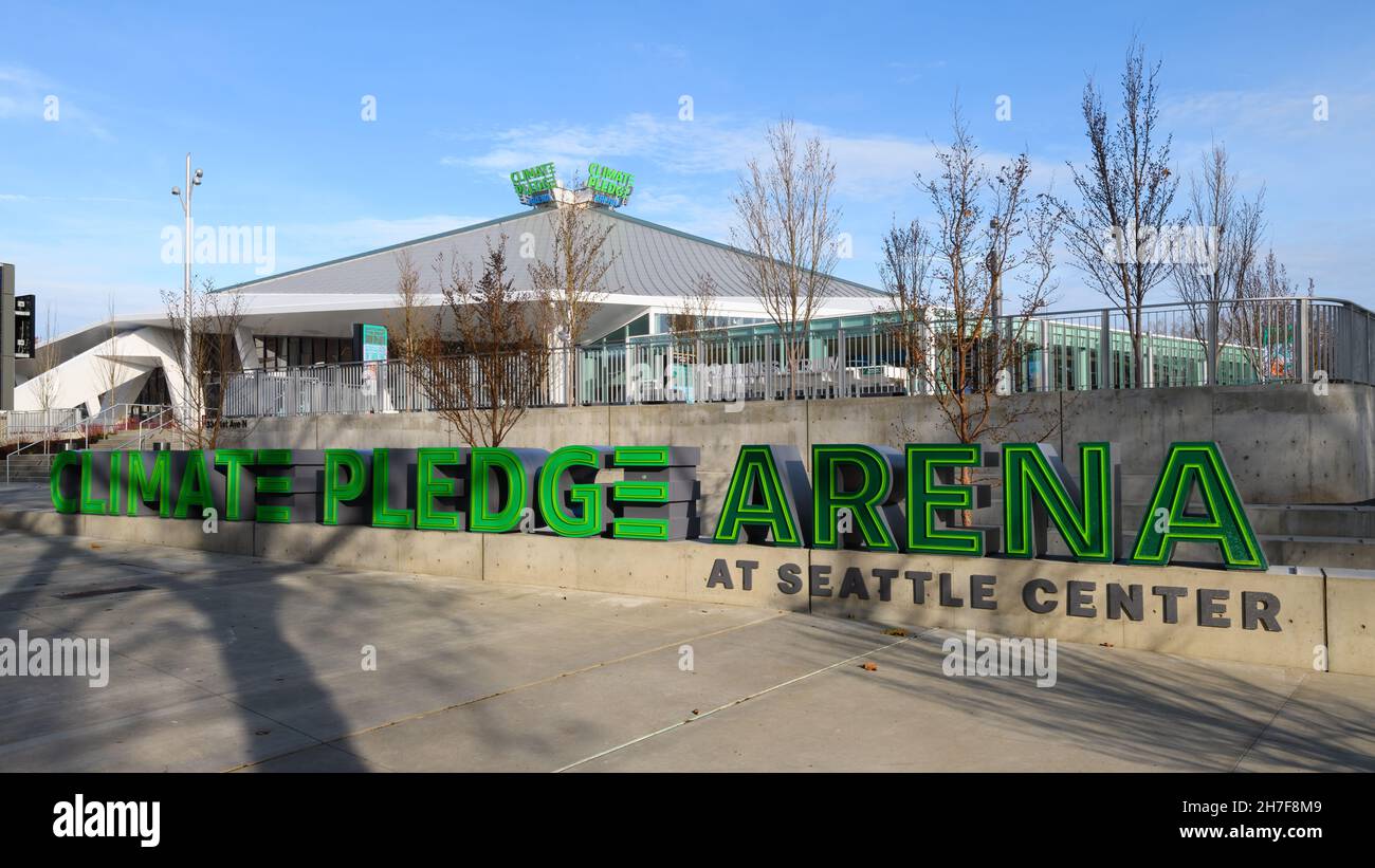 Seattle - 21. November 2021; Schatten von Bäumen überqueren den Bürgersteig und berühren das Schild für die Climate Pledge Arena in Seattle unter blauem Himmel Stockfoto