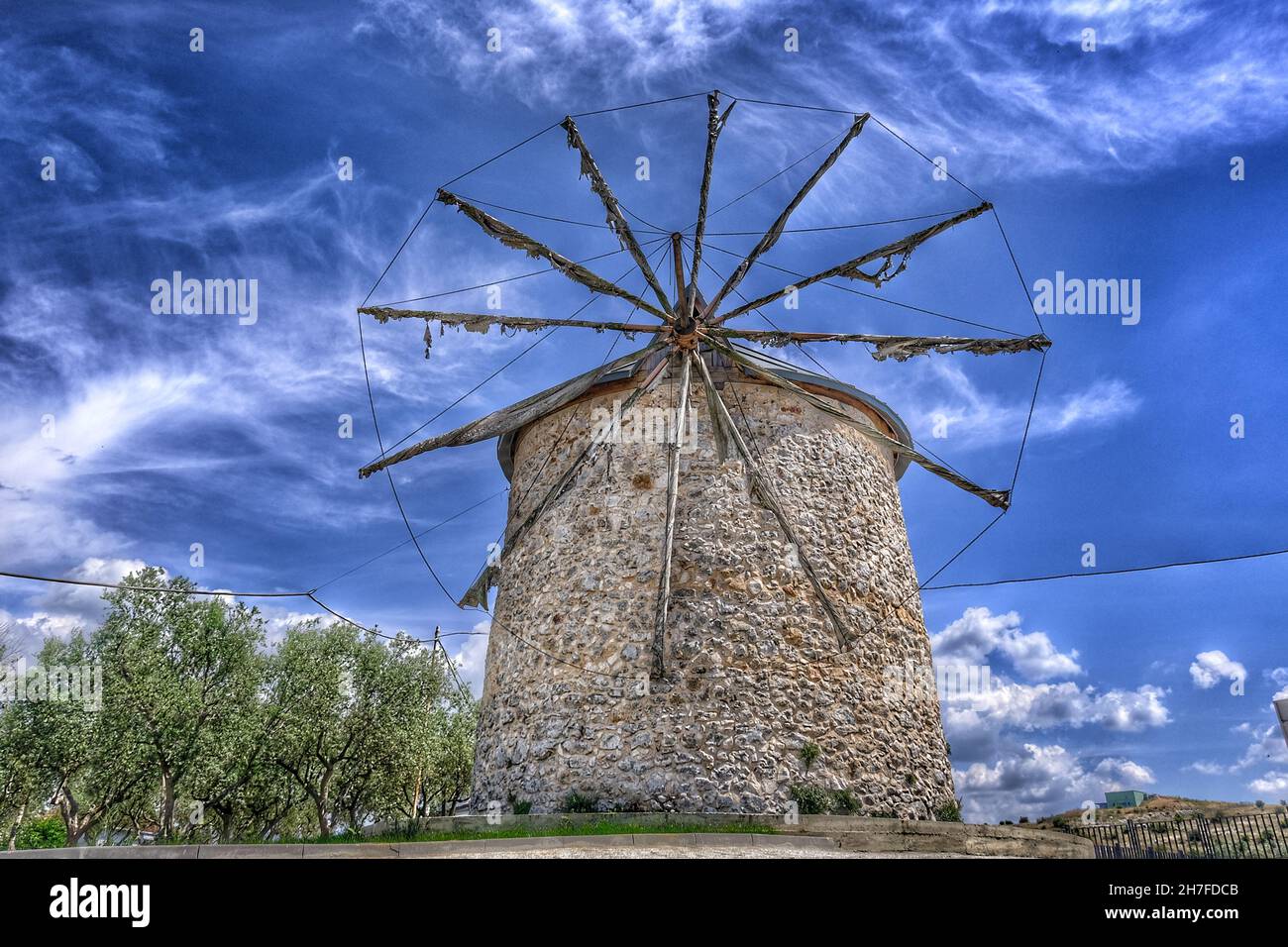 Alte Windmühle in Golyazi (uluabat) bursa und es Hauptstruktur aus Stein und mit hölzernen Propeller mit herrlichen blauen Himmel und grünen Baum Stockfoto