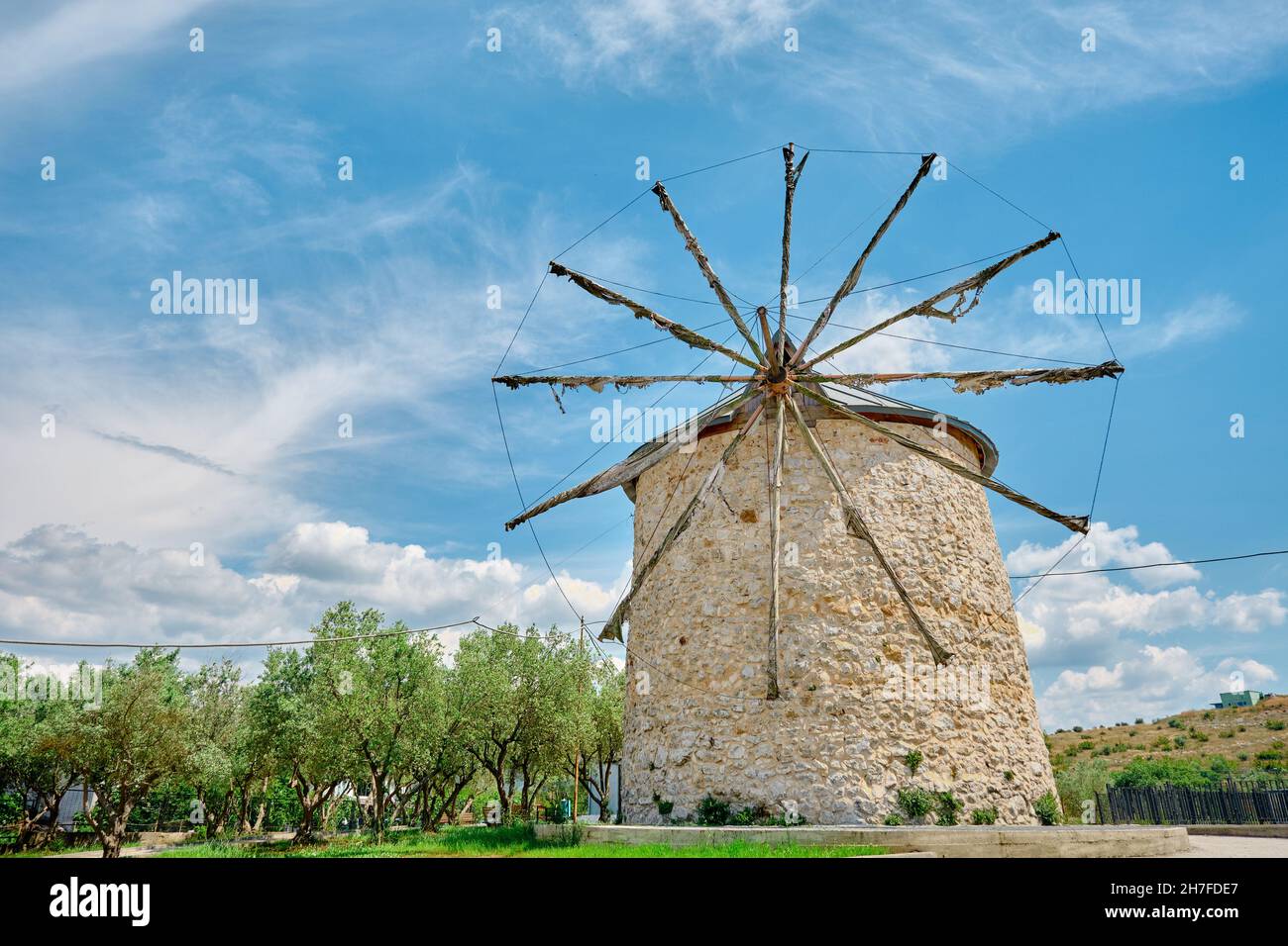 Alte Windmühle in Golyazi (uluabat) bursa und es Hauptstruktur aus Stein und mit hölzernen Propeller mit herrlichen blauen Himmel und grünen Baum Stockfoto