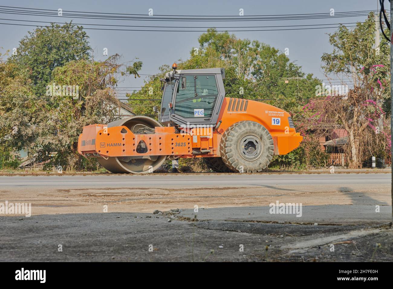 Phayao, Thailand - Jan 27, 2021: Orange One Wheel Road Roller arbeitet auf Asphalt Road Stockfoto