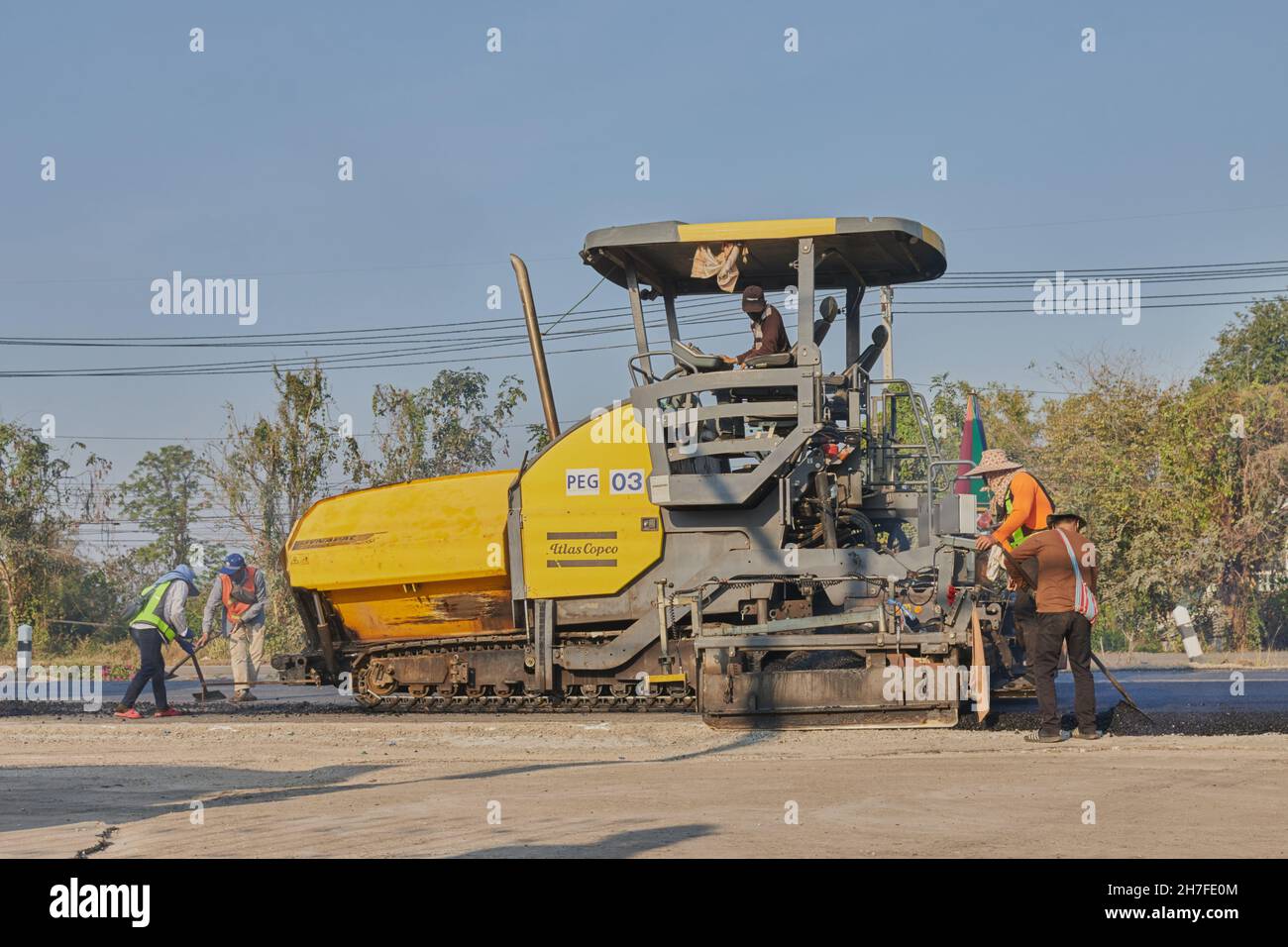 Phayao, Thailand - 27. Jan 2021: Asphaltfertiger und LKW und Arbeiter in Weitwinkel, die auf der Straße arbeiten Stockfoto