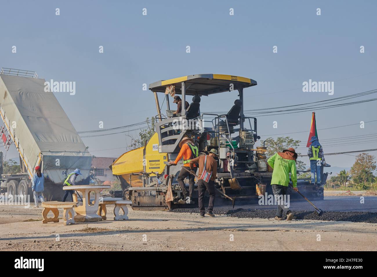 Phayao, Thailand - 27. Jan 2021: Back of Worker und Asphalt Paver and Truck auf der Asphalth Road Stockfoto