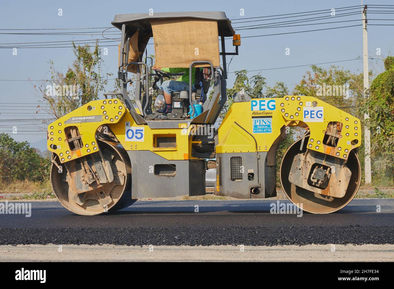 Phayao, Thailand - 27. Jan 2021: Zoom Side View Worker und Road Roller auf Asphalt Road Stockfoto