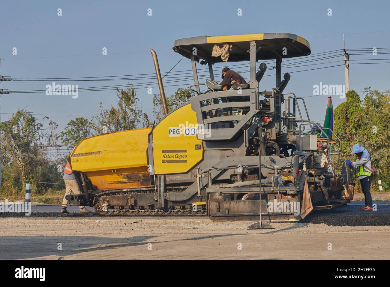 Phayao, Thailand - 27. Januar 2021: Asphaltfertiger und LKW und drei Arbeiter arbeiten auf der Straße Stockfoto