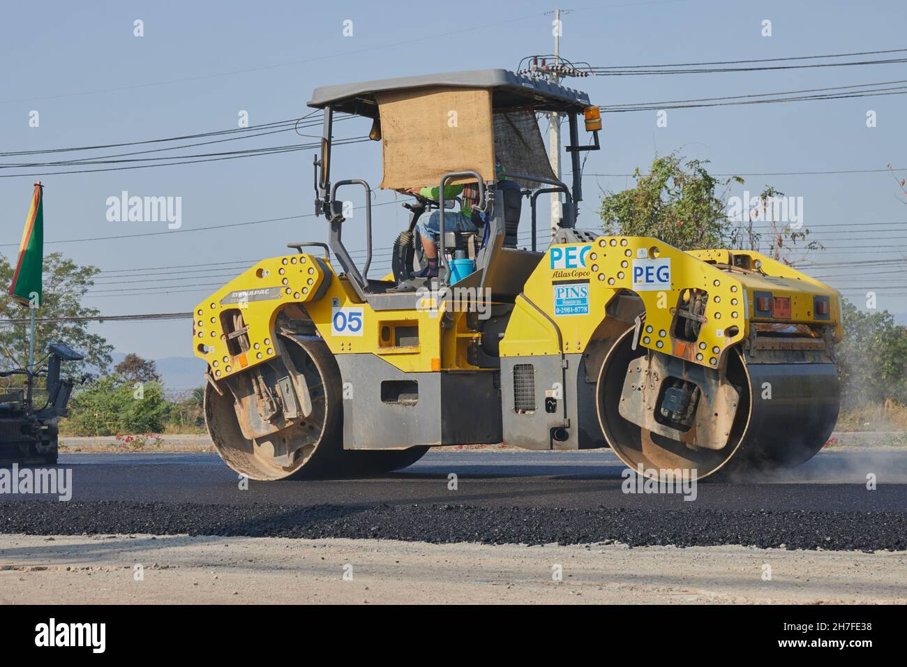 Phayao, Thailand - 27. Jan 2021: Zoom Back View Worker and Road Roller on Asphalt Road Stockfoto