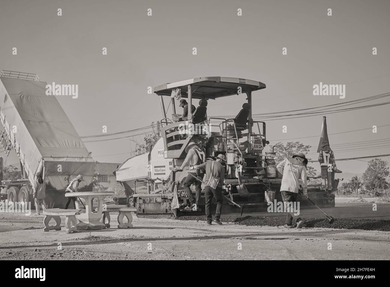 Phayao, Thailand - 27. Januar 2021: Rücken von Black and White Worker und Asphalt Paver und Truck auf der Asphaltstraße Stockfoto