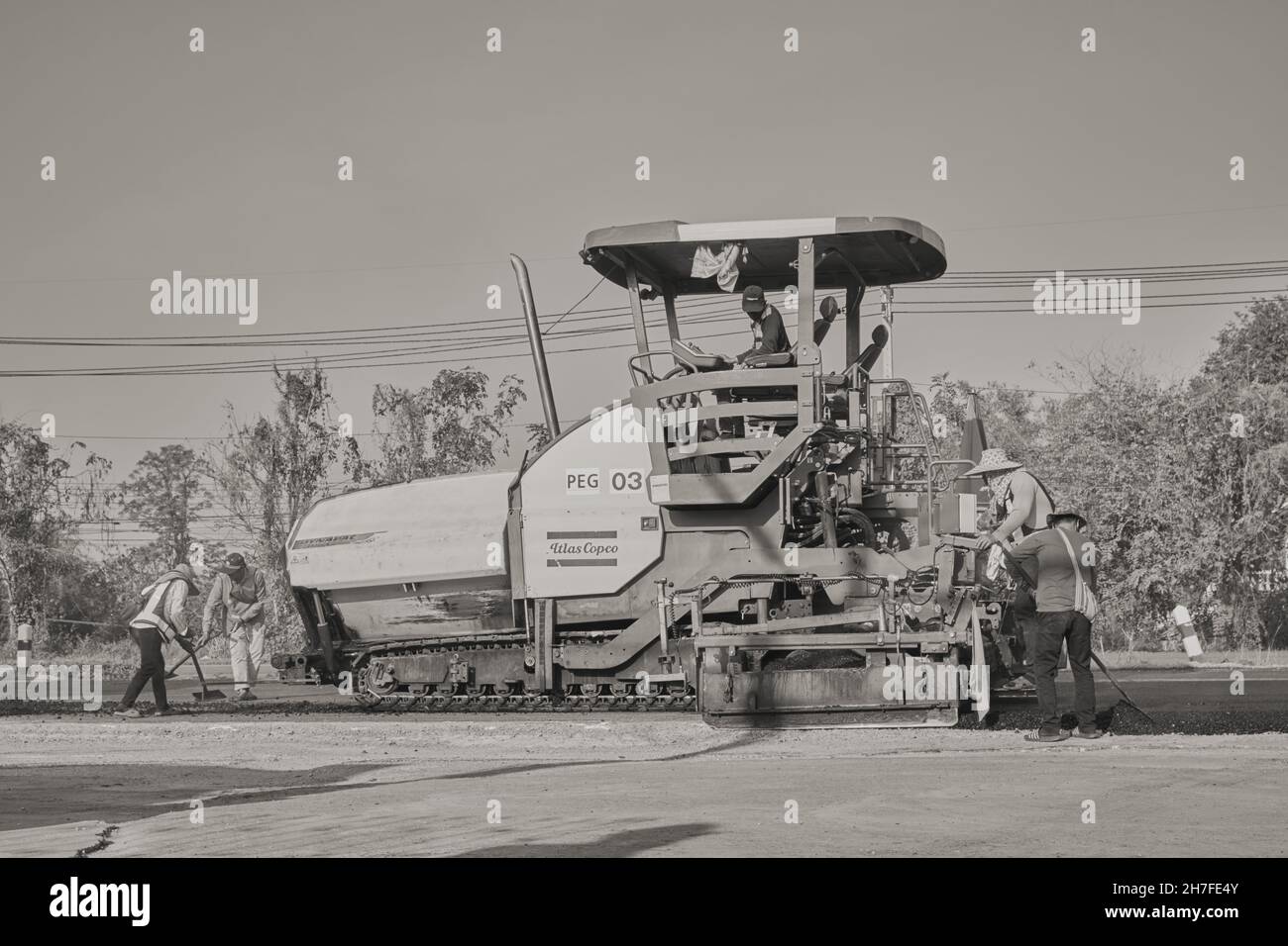 Phayao, Thailand - 27. Jan 2021: Weitwinkel schwarz-weiß Asphalt Pfänder und LKW und Arbeiter arbeiten auf der Straße Stockfoto