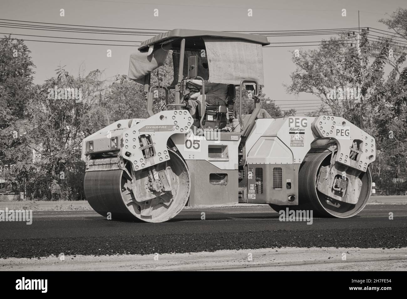 Phayao, Thailand - 27. Jan 2021: Zoom View Black and White Worker und Road Roller auf Asphalt Road Stockfoto