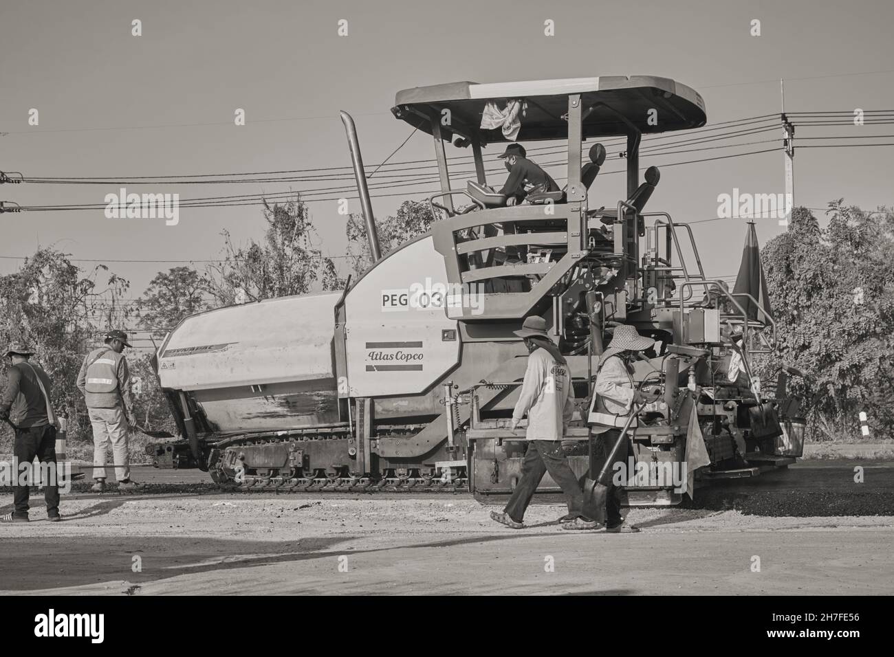 Phayao, Thailand - 27. Januar 2021: Schwarz-Weiß-Asphalt-Pflaster und Lastwagen und fünf Arbeiter, die auf der Straße arbeiten Stockfoto