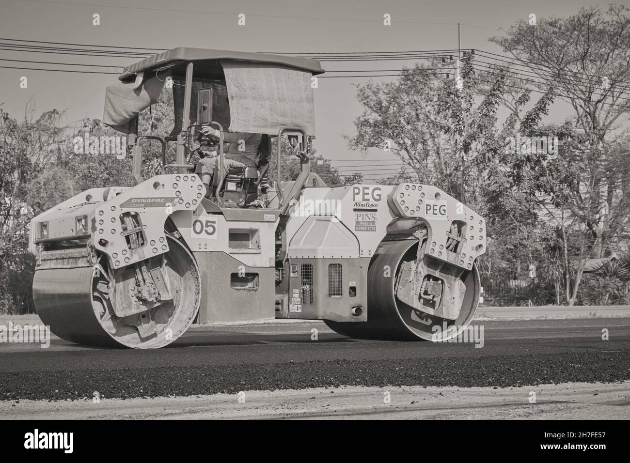Phayao, Thailand - 27. Jan 2021: Black and White Worker und Road Roller am linken Rahmen auf Asphalt Road Stockfoto