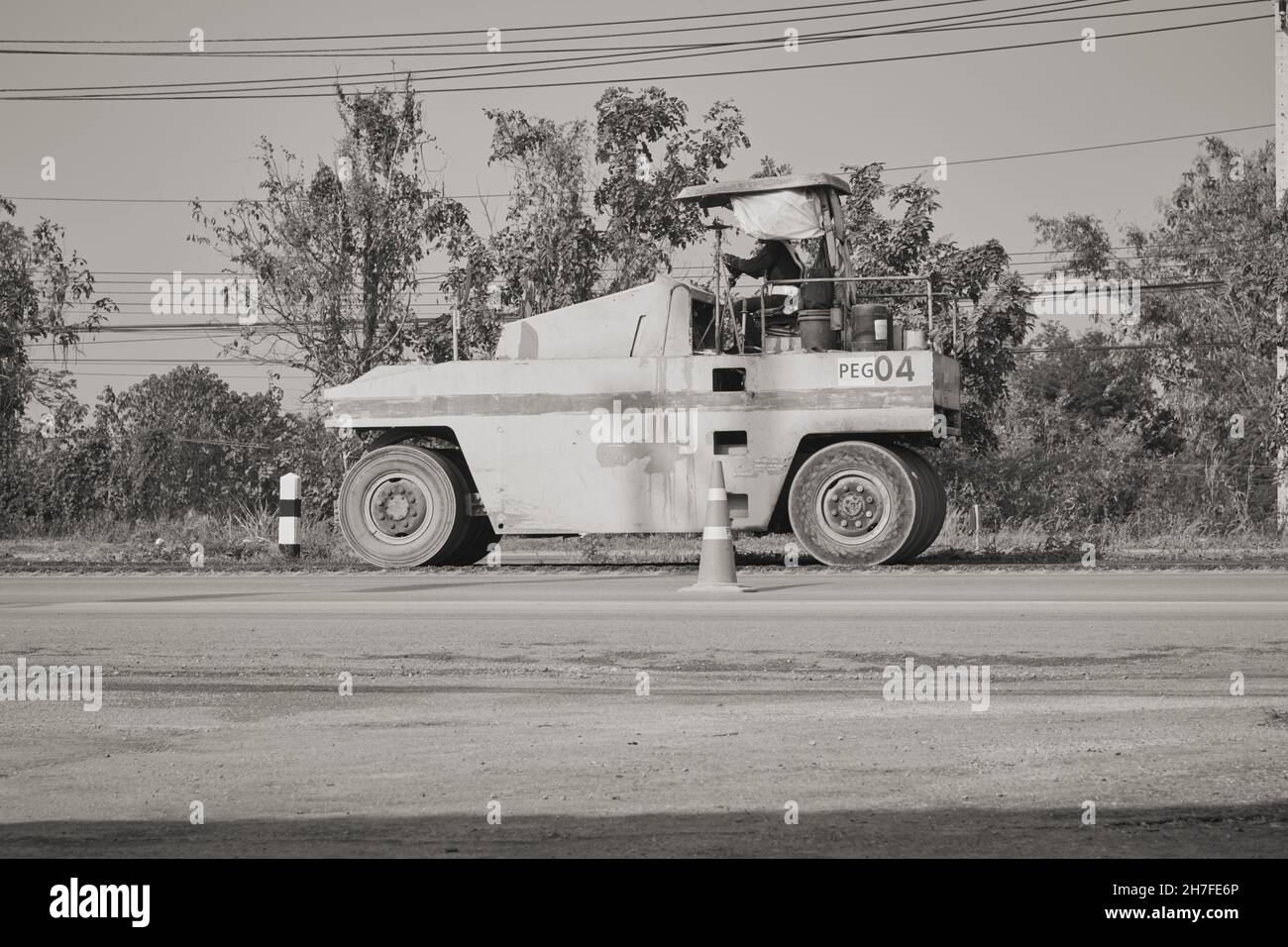 Phayao, Thailand - 27. Jan 2021: Schwarz-Weiß-Seitenansicht Five Wheel Road Roller, der auf Asphalt Road arbeitet Stockfoto
