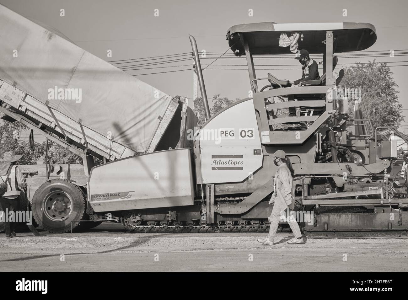 Phayao, Thailand - 27. Jan 2021: Schwarz-Weiß-Asphalt-Pfaver und LKW und Arbeiter arbeiten auf der Straße Stockfoto